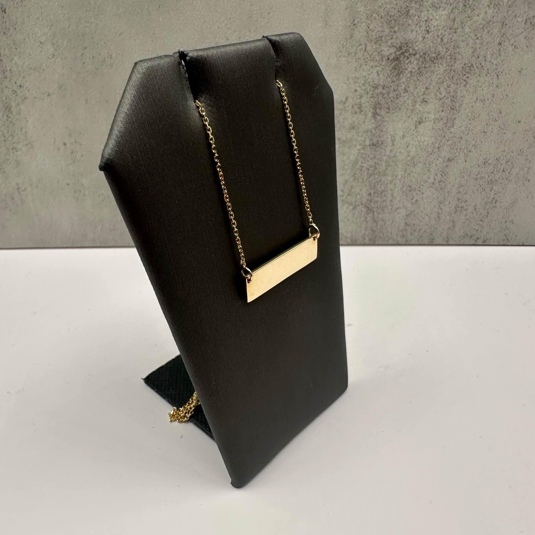 This stylish Nameplate Necklace in 14kt yellow gold features a 19-inch length, offering versatility for various looks. Weighing 3.5 grams, it is both durable and comfortable for all-day wear. The lobster clasp ensures a secure fit. In 9/10