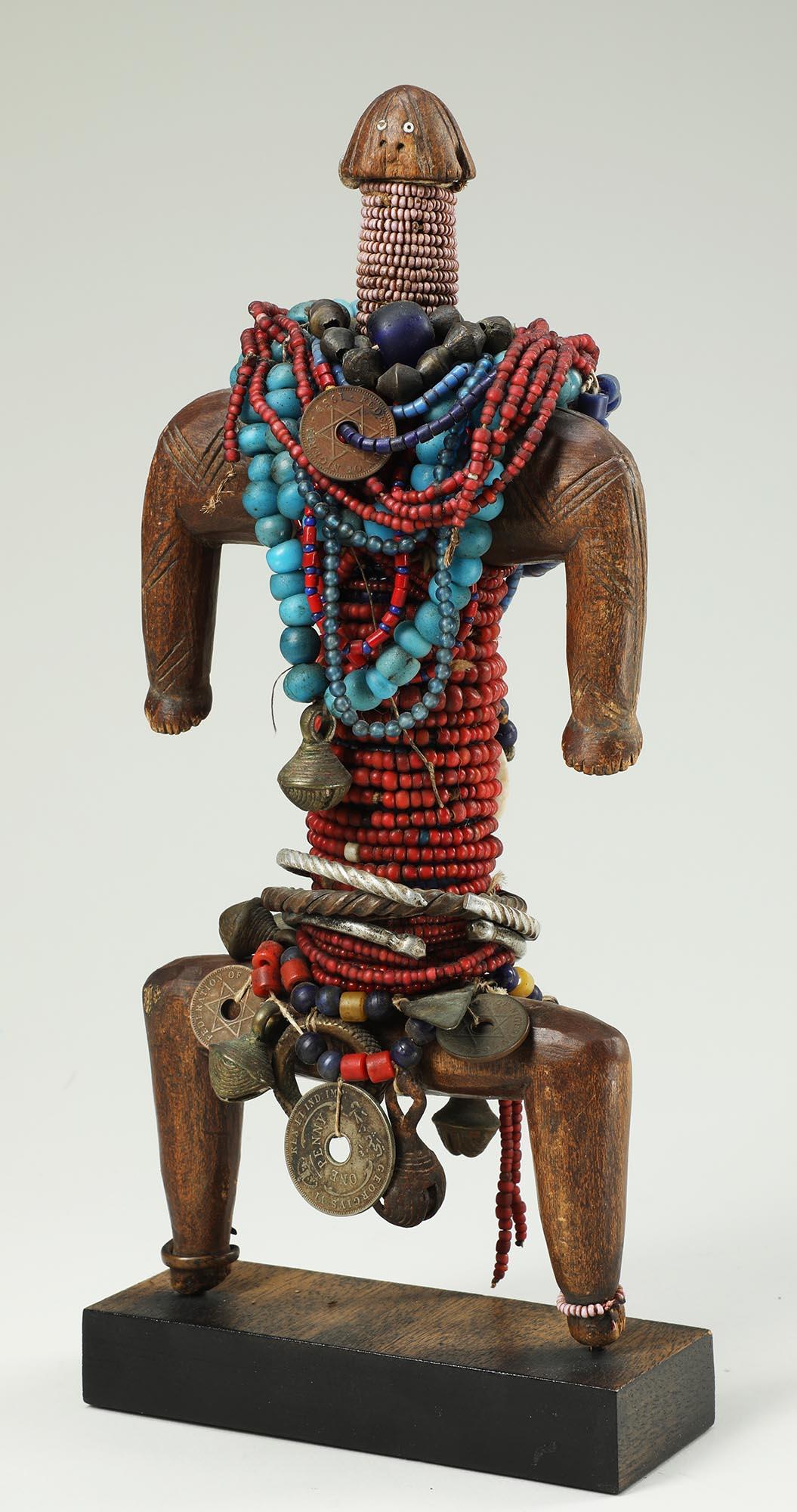 Muñeca Namji con cuentas, bayas de vaca, monedas y anillos de metal, Camerún Mediados del siglo XX Tallado a mano en venta