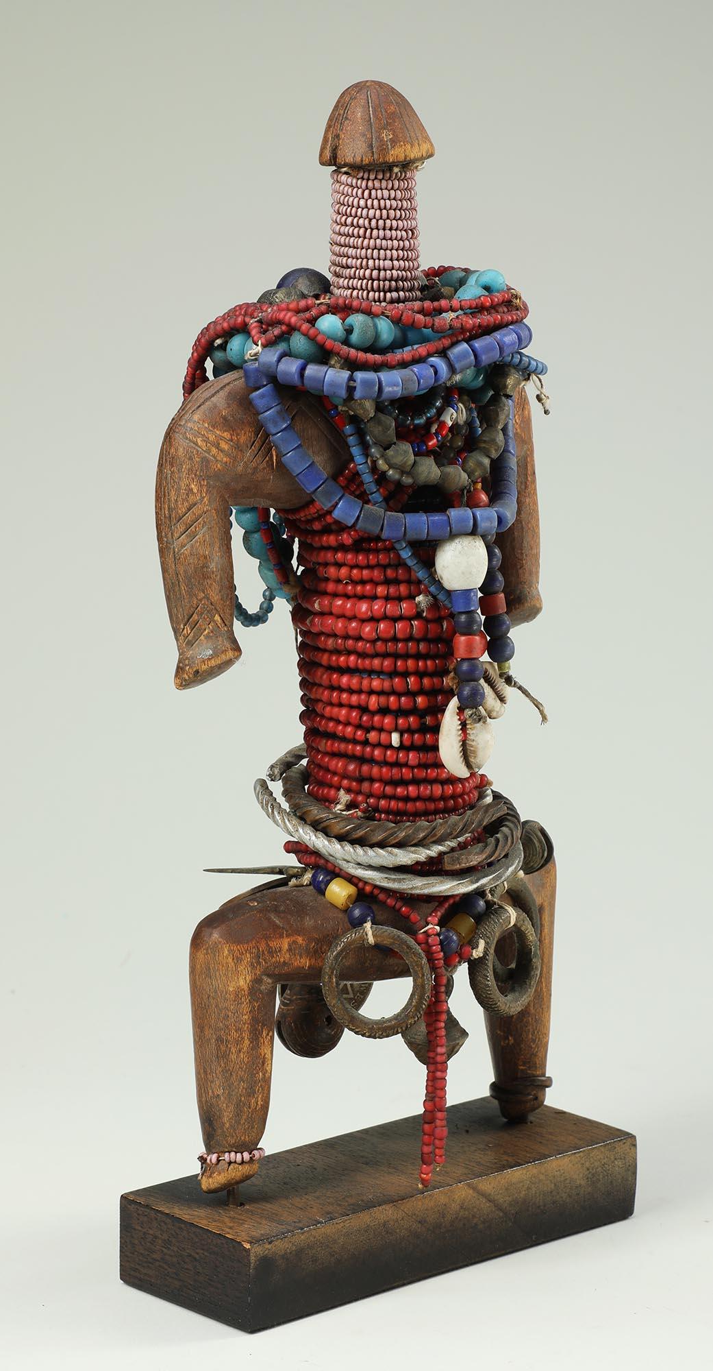 Muñeca Namji con cuentas, bayas de vaca, monedas y anillos de metal, Camerún Mediados del siglo XX Madera en venta