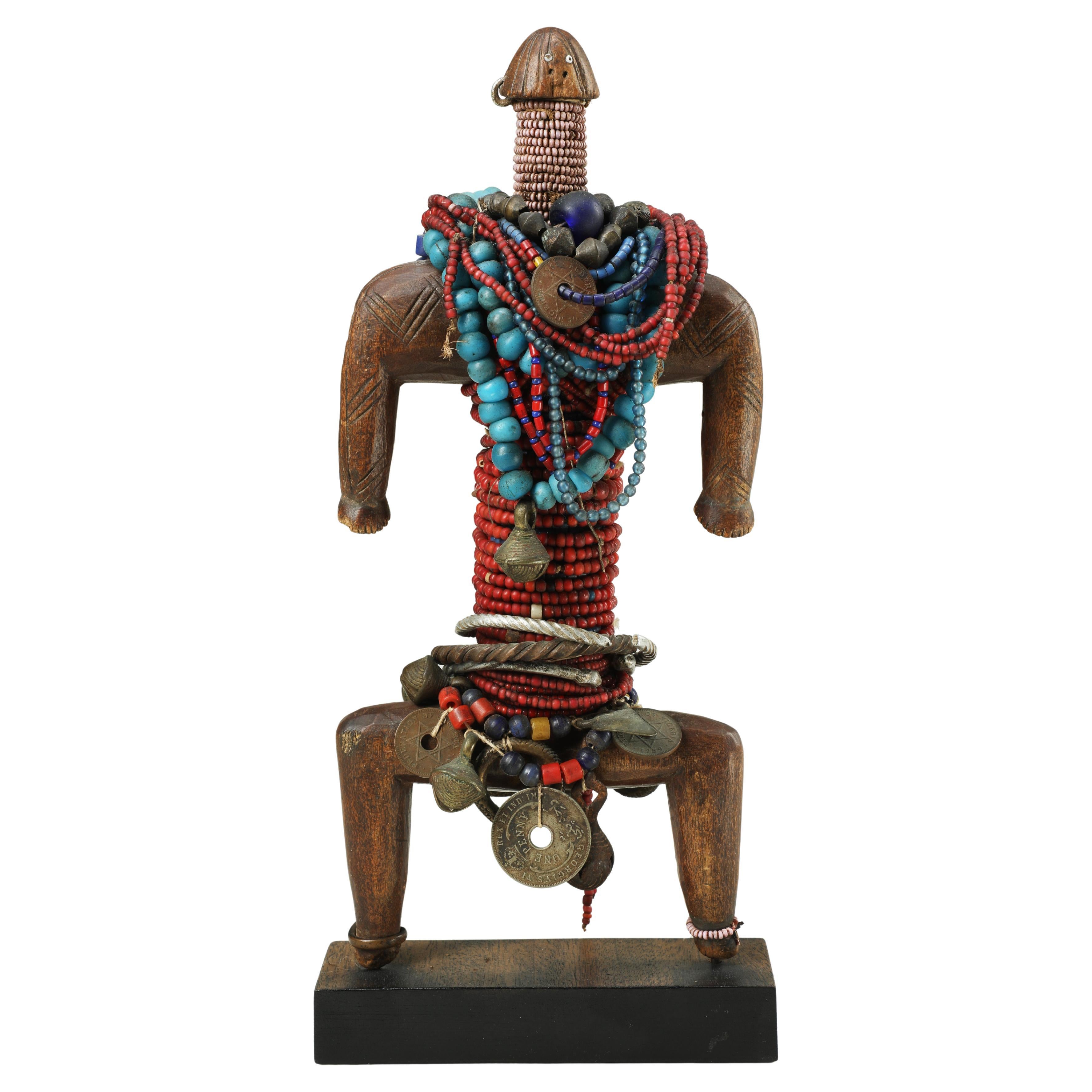 Muñeca Namji con cuentas, bayas de vaca, monedas y anillos de metal, Camerún Mediados del siglo XX en venta