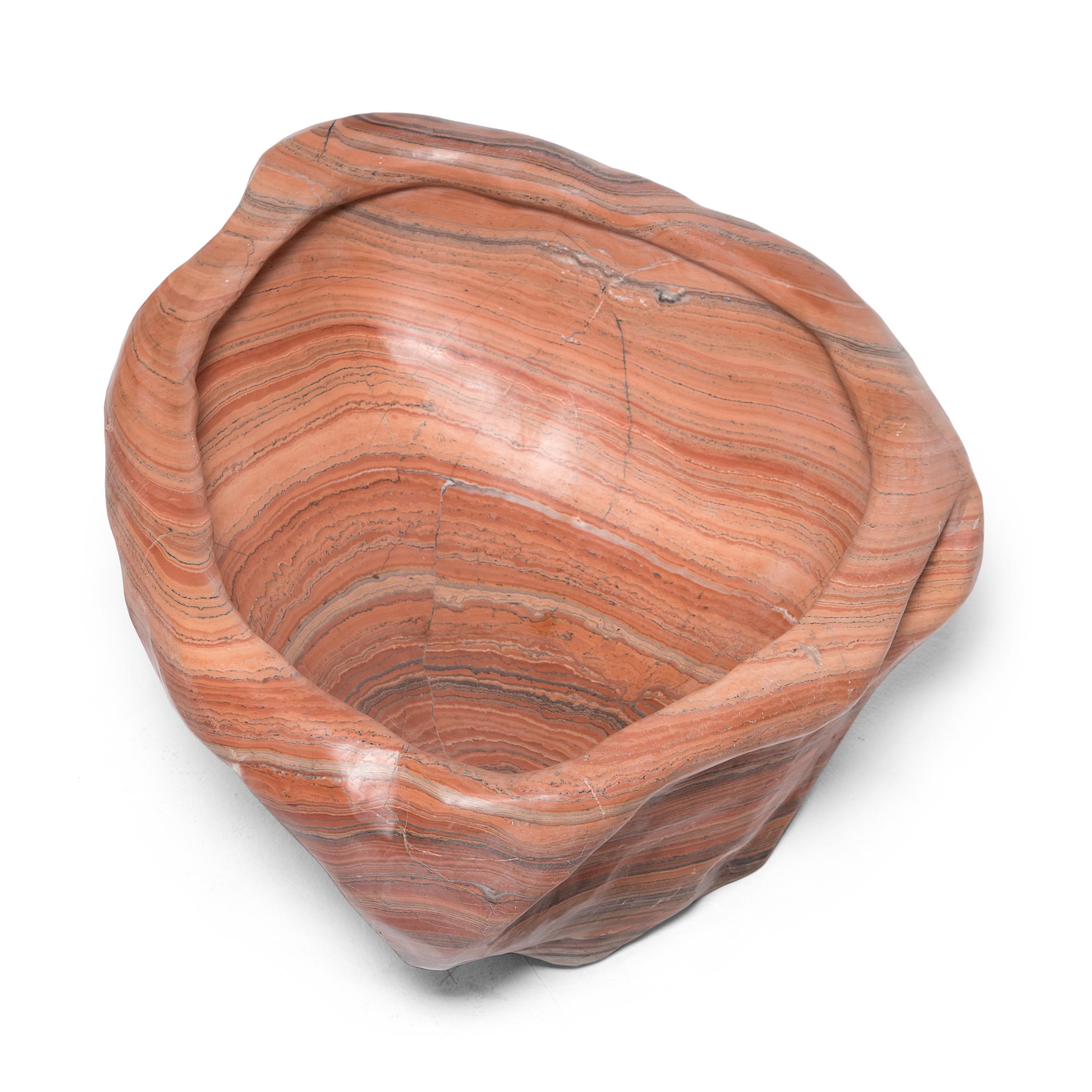 Shaped from stone sourced from the Nanyang region of China's southern coast, this colorful stone basin swirls with a gorgeous pattern of orange, pink, and grey strata. Carved with an asymmetrical form and smoothed to enhance its warm coloring, the