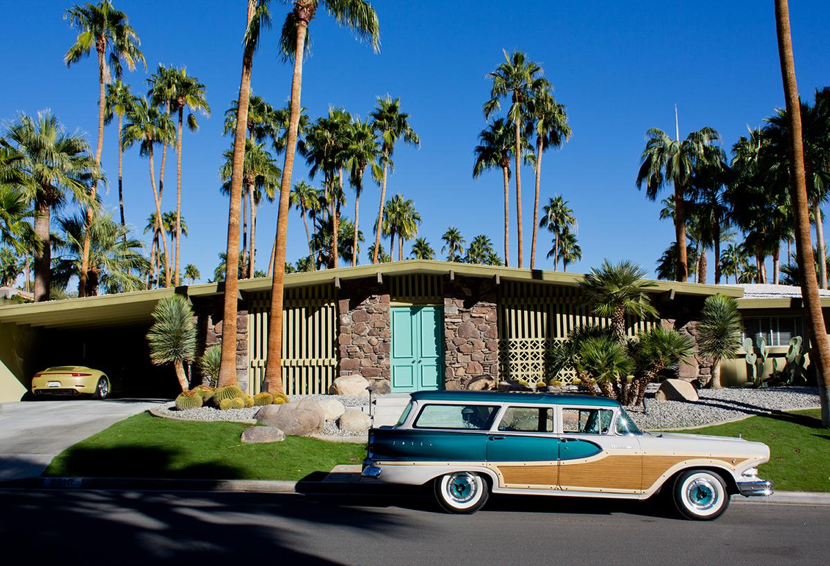 And the Cars to Match by Nancy Baron is a 15 x 22 inch archival pigment print, available in an edition of 10. This photograph features the outside of a mid century modern home and 2 cars that match the colors of the surrounding area. This photograph