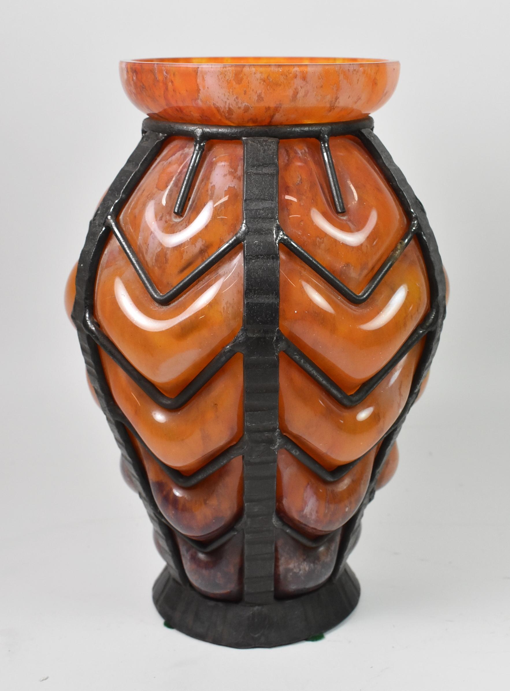 Un vase en verre d'art français Art Déco de Nancy Daum et Louis Majorelle. Ce vase étonnant est composé d'un vase en verre soufflé aux nuances variées d'orange, de blanc et de brun, entouré d'une cage en fer forgé fabriquée à la main. Non signée.
