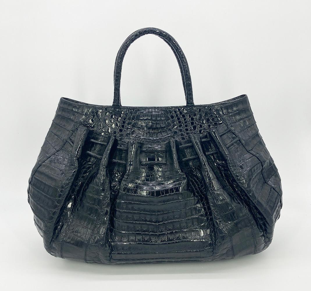 Nancy Gonzalez Black Crocodile Tote in excellent condition. Black crocodile exterior trimmed with drawstring exterior front and back pockets and double top handles. Magnetic top closure opens to a salmon suede interior with one slit and one zipped