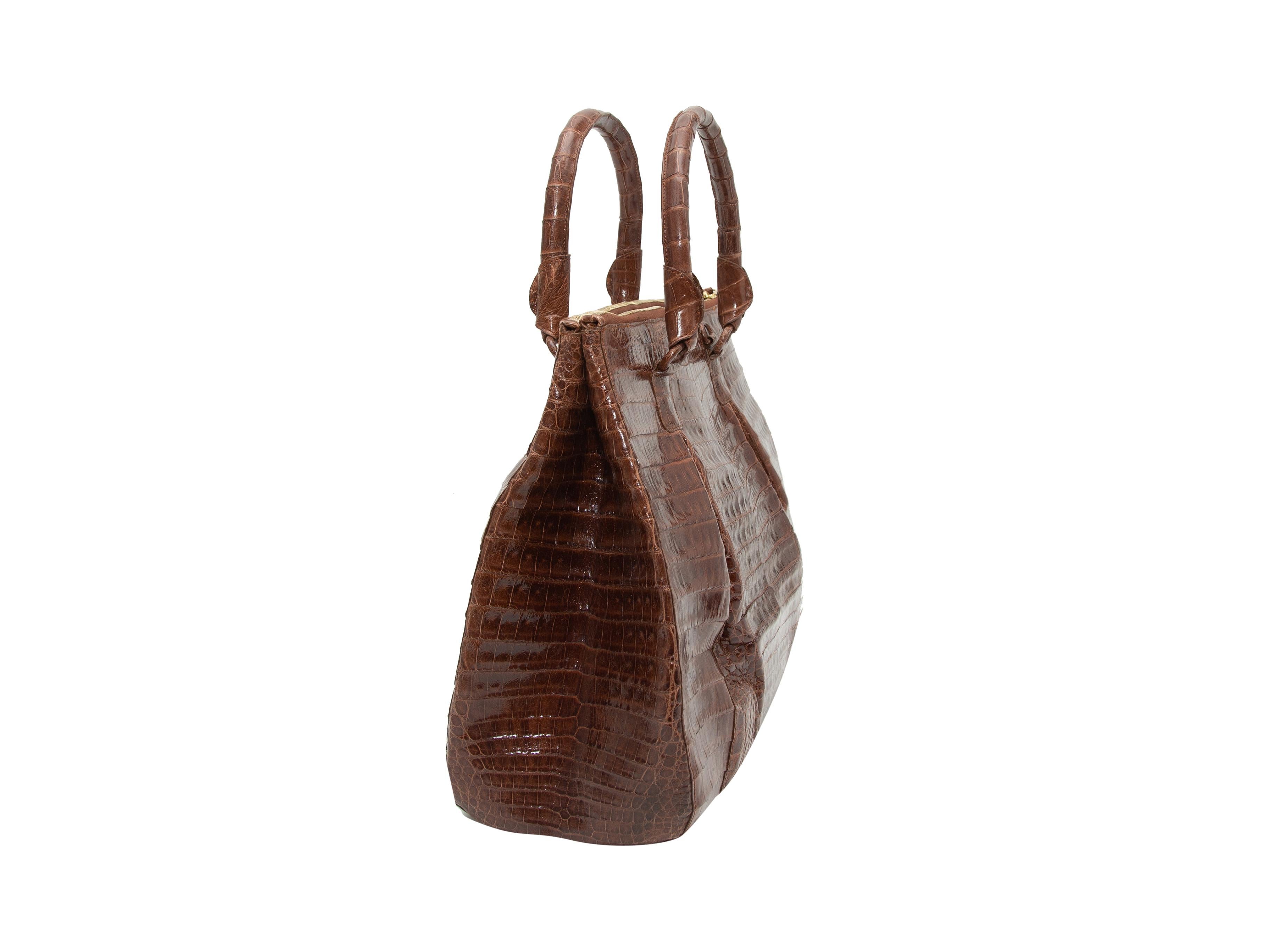 Product details: Brown alligator handbag by Nancy Gonzalez. Dual rolled top handles. Optional shoulder strap. Zip closure at top. 13