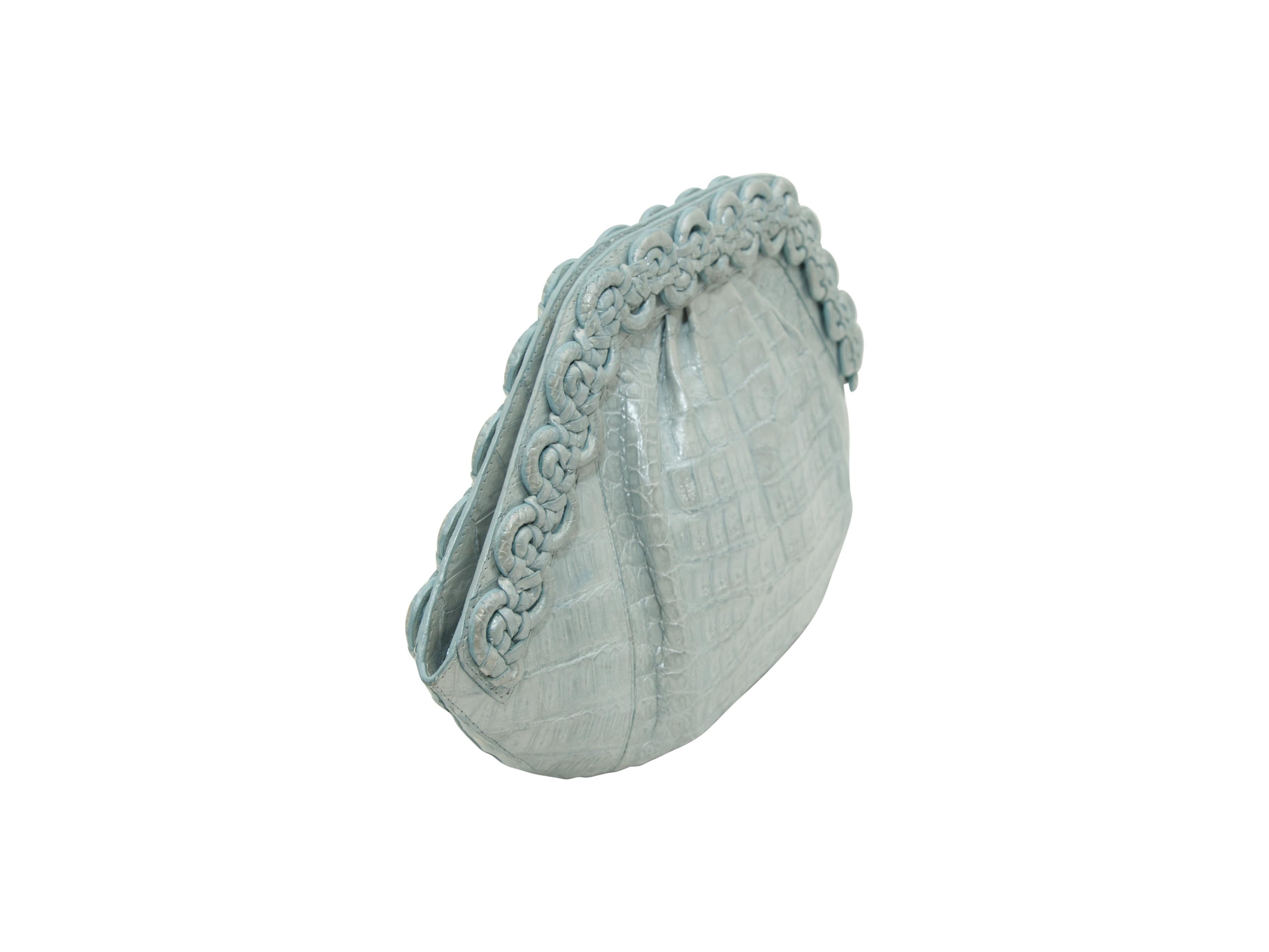 Product details:  Light Blue Nancy Gonzalez Crocodile Clutch.  The clam shell-shaped clutch has braided crocodile trim along the edges of the bag, and is lined in suede. The clutch has one zippered compartment, and an open compartment for your