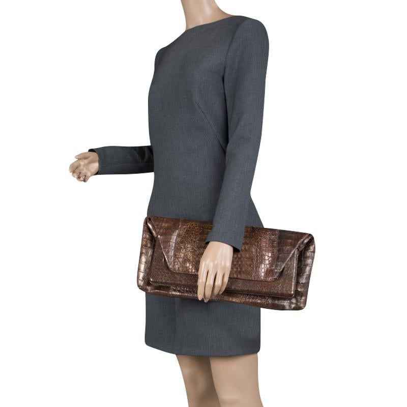 Fashioned in a fold-over silhouette, this Nancy Gonzalez clutch is designed in a chic metallic brown body and a framed body. It features a rectangular pattern and opens to reveal a suede lined interior that can hold all your evening essentials.