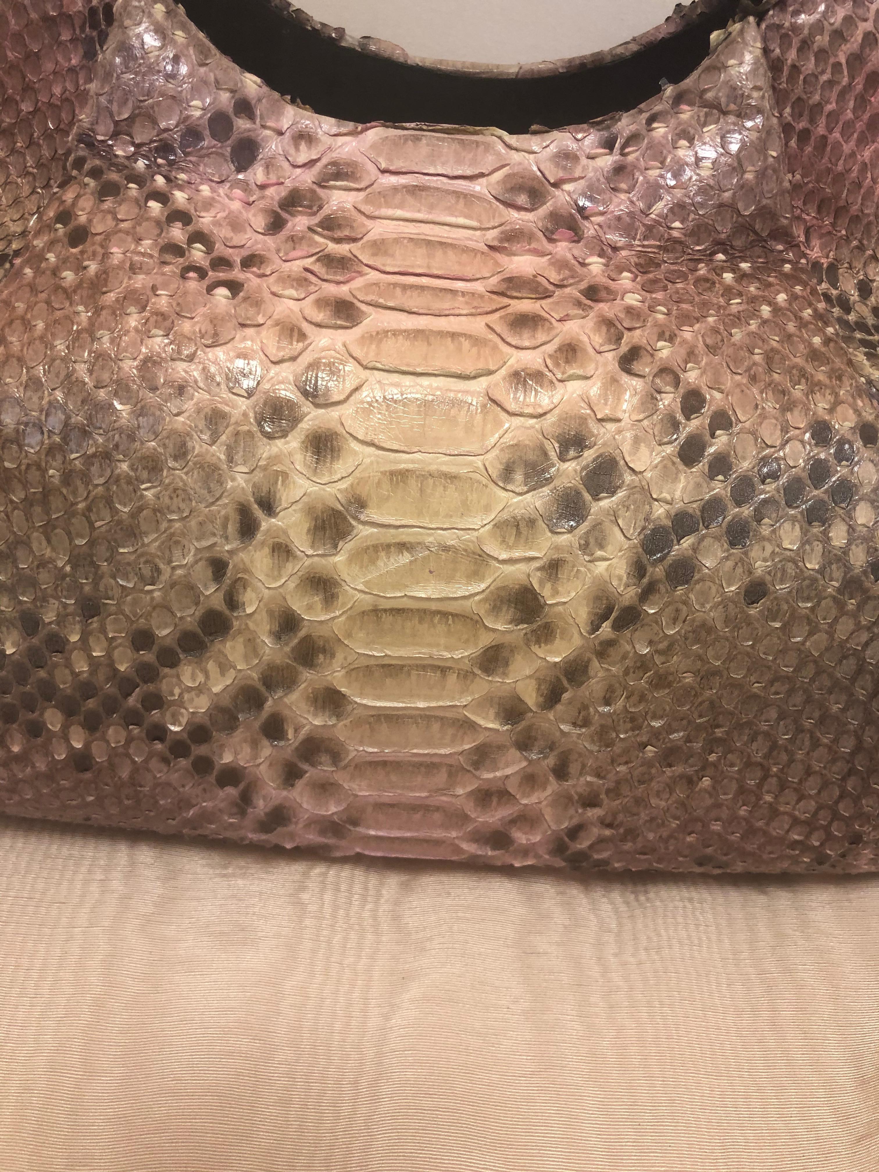 Well crafted bag with purple/pink/brown colors. It is soft sided and therefore practical, as well as elegant.  The main body of the bag is python with the handles and trim being crocodile. The light purple suede lining has a zipped pocket as well as