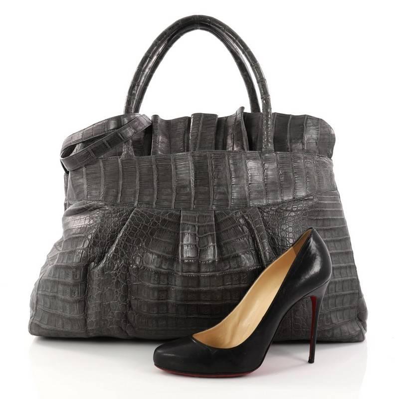 This authentic Nancy Gonzalez Ruffle Convertible Tote Crocodile Large is the perfect combination of luxurious style and polished aesthetic made for the modern woman. Crafted from genuine grey crocodile skin, this beautiful tote features dual-rolled