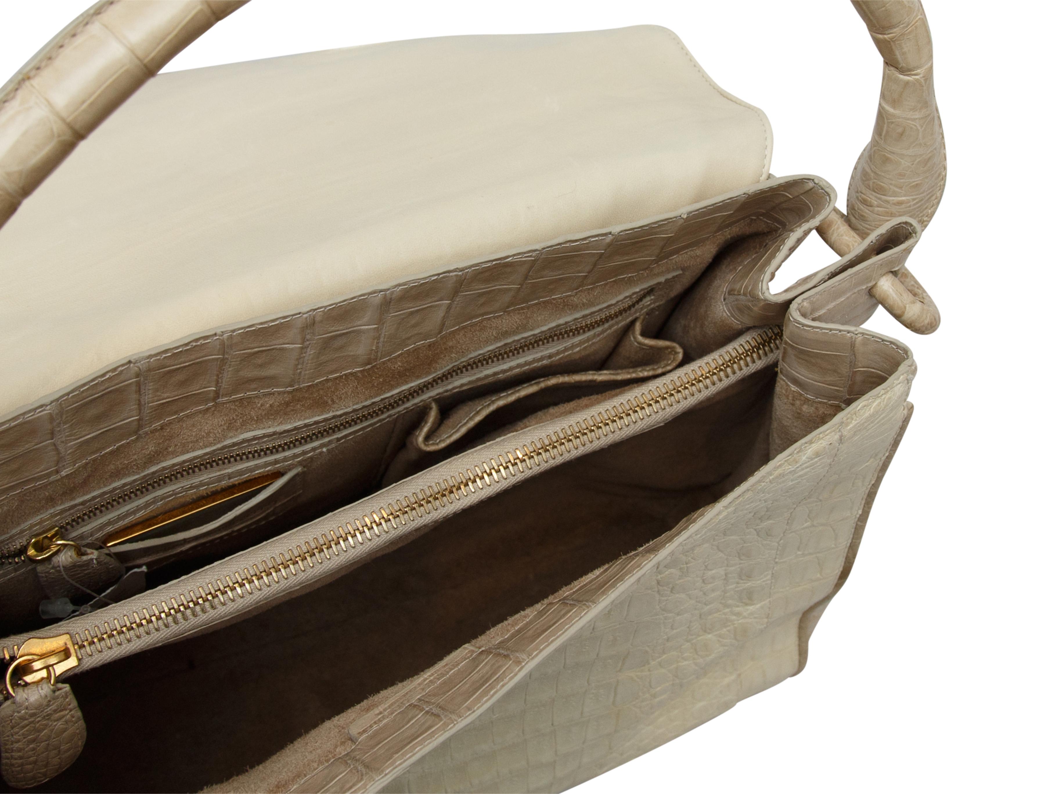 Product details: White and beige crocodile handbag by Nancy Gonzalez. Single shoulder strap. Interior zip pockets. Flap closure at top. 11