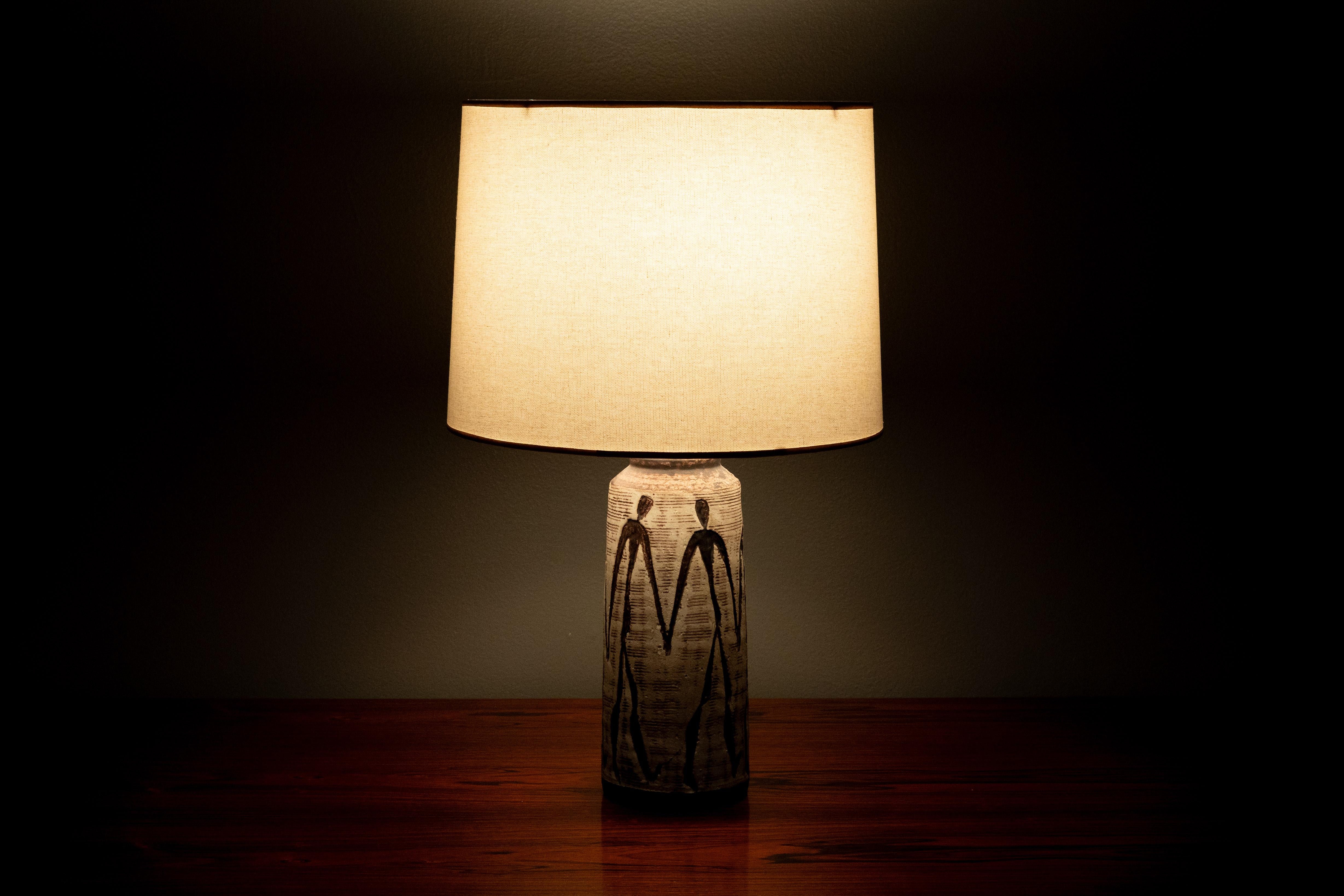 USA, ca. 1950s. A scarce table lamp by noted VT artist Nancy Wickham (1923-1987). Features handmade stoneware ceramic body in organic tapering form - decorated in one of Wickham’s signature motifs of lithe human forms over a subtle textured glaze.