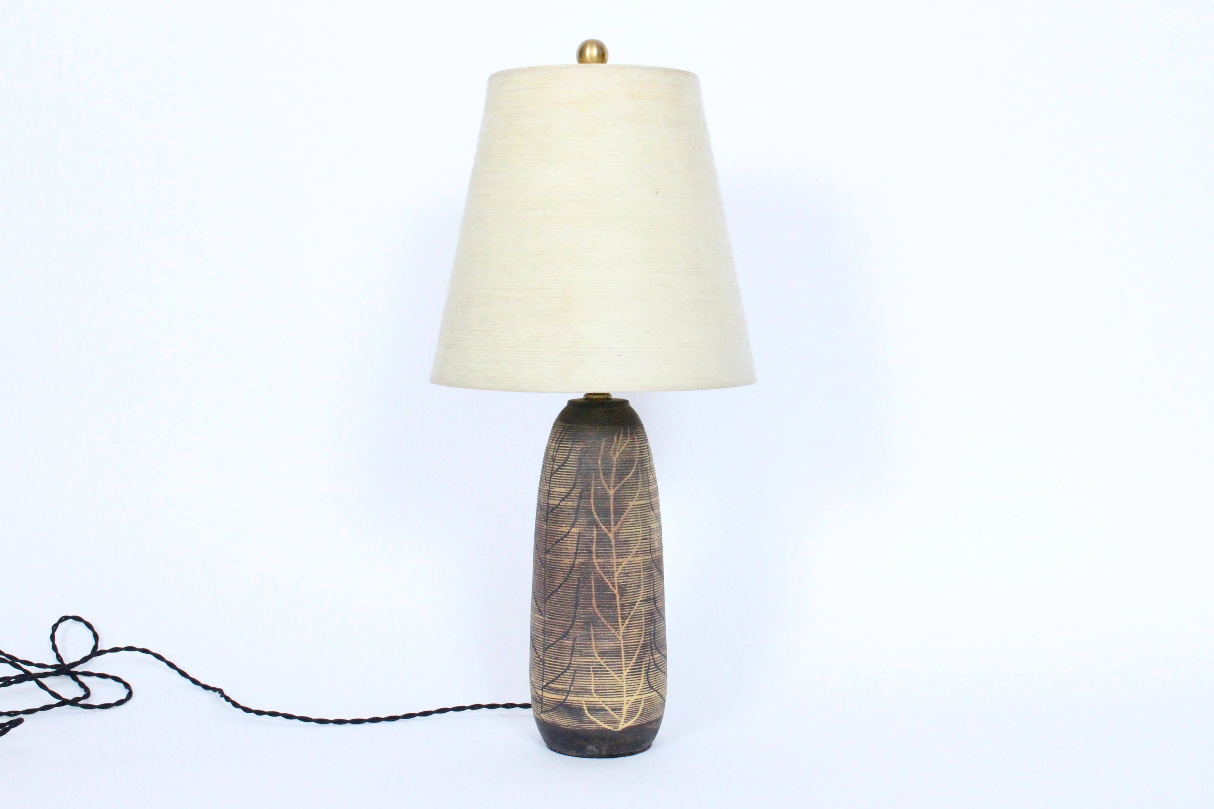 Vermont Potter Nancy Wickham Boyd for Design-Technics hand carved organic modern stoneware table lamp. Featuring a glazed handcrafted tapered cylindrical ceramic form with leaf and branch designs in mustard, olive and brown earthen natural tones and