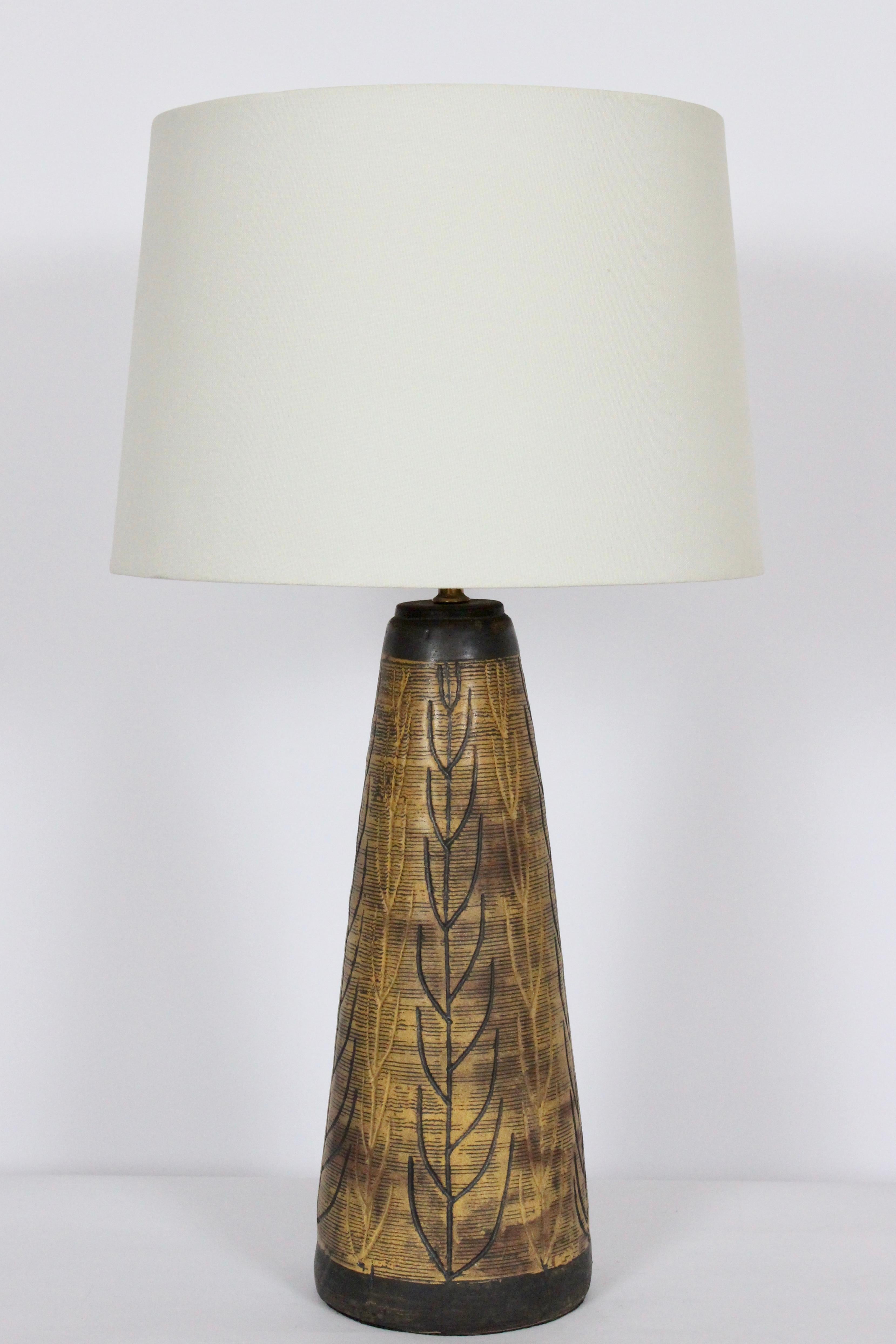 Large Vermont Potter Nancy Wickham Boyd for Design-Technics hand carved organic modern stoneware lamp. Featuring a glazed hand crafted tapered cylindrical ceramic form with leaf and branch designs in mustard, olive and earthen natural tones and