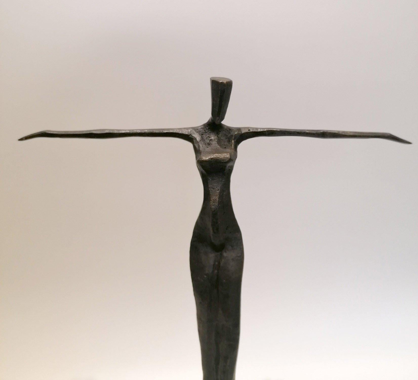 Amena es una llamativa escultura de bronce que personifica la elegancia y el minimalismo. La pieza muestra una figura humana femenina muy estilizada, caracterizada por unos miembros alargados y una forma abstracta. 

La figura se mantiene erguida