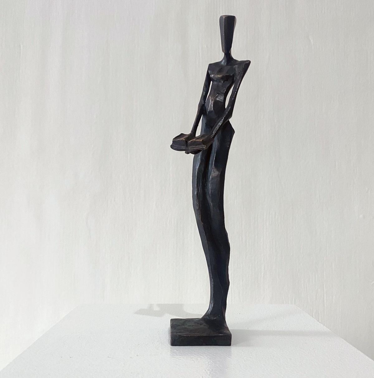 Woman with Book is an elegant figurative bronze sculpture by Nando Kallweit.

Modelled on modern youthful postures but with a nod to the importance of heritage through the stylised Egyptian-influenced head. A lovely piece on its own or with a group