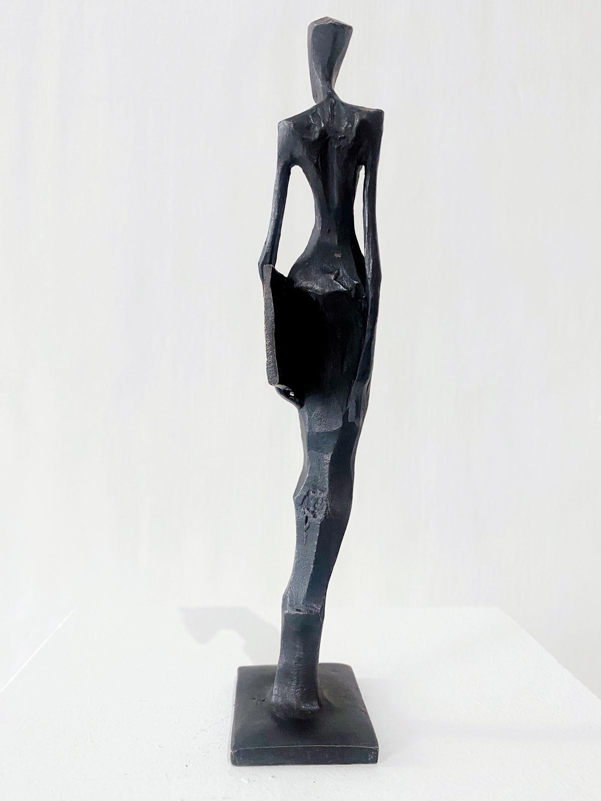 Woman with Photo is an elegant figurative bronze sculpture by Nando Kallweit.

Modelled on modern youthful postures but with a nod to the importance of heritage through the stylised Egyptian-influenced head. A lovely piece on its own or with a group