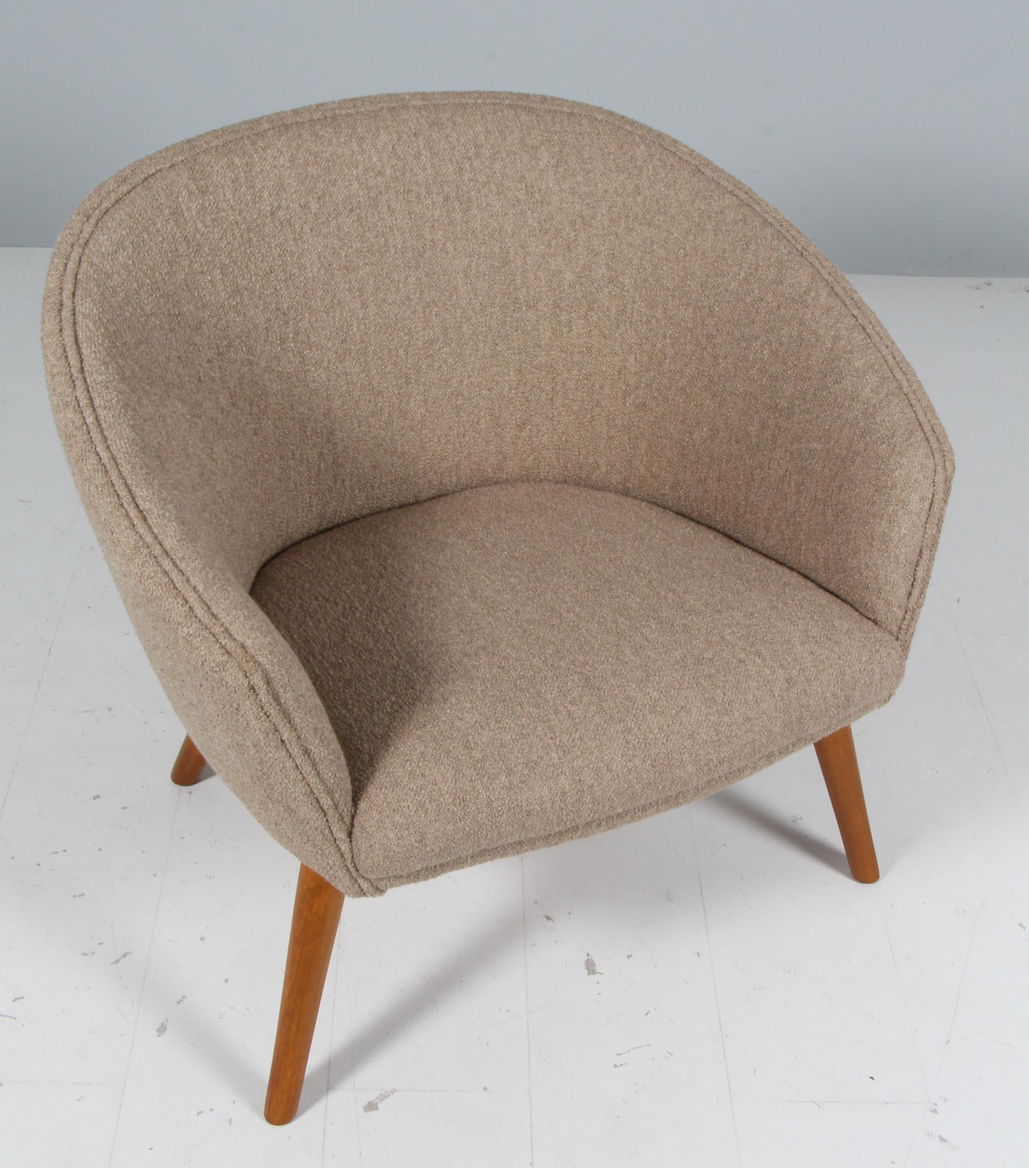 Tumbona de respaldo curvo con patas de haya teñida y tapizado nuevo de boucle.  Diseñado por Nanna Ditzel y producido en Dinamarca por A.P. Robado, hacia la década de 1950. 