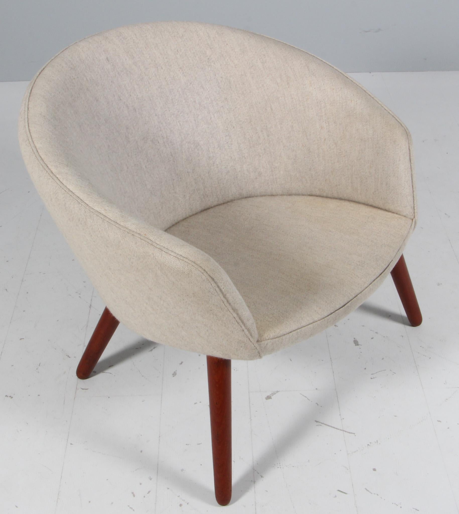 Tumbona de respaldo curvo con patas macizas de teca y tapicería original de lana Savak.  Diseñado por Nanna Ditzel y producido en Dinamarca por A.P. Robado, hacia la década de 1950. 