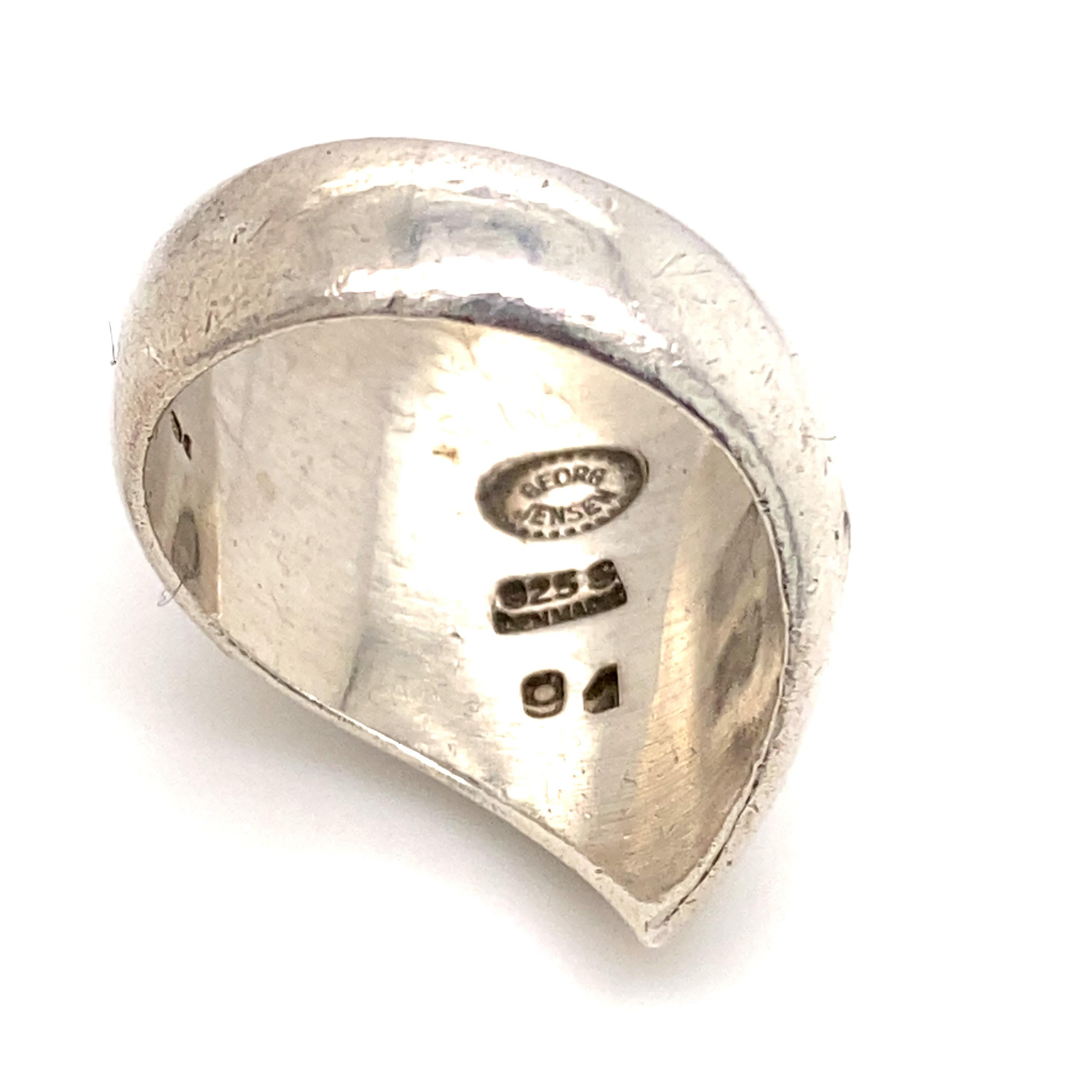 Silberring von Nanna Ditzel für Georg Jensen, Dänemark um 1968

Als elegante, geschwungene und wellenförmige Silberskulptur sitzt dieser Ring wunderschön am Finger und fängt das Licht ein, wenn man ihn aus verschiedenen Winkeln betrachtet.

Nanna
