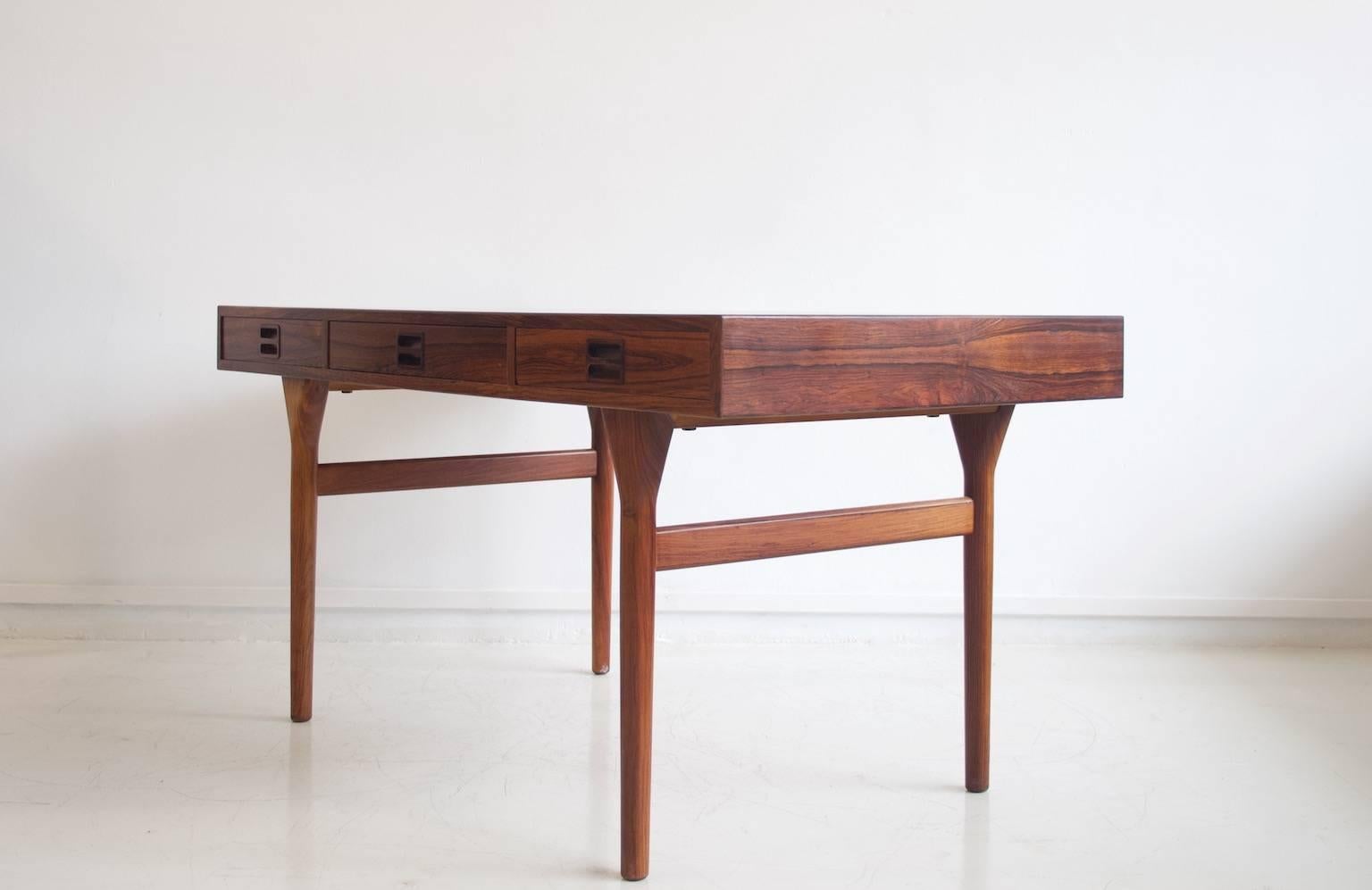 Desk designed by Nanna Ditzel for Søren Willadsen Møbelfabrik before 1958. Frame made of solid rosewood, surfaces with veneer, fitted with three drawers made of beech. Restored, very good condition, shows only minimal age-related wear.