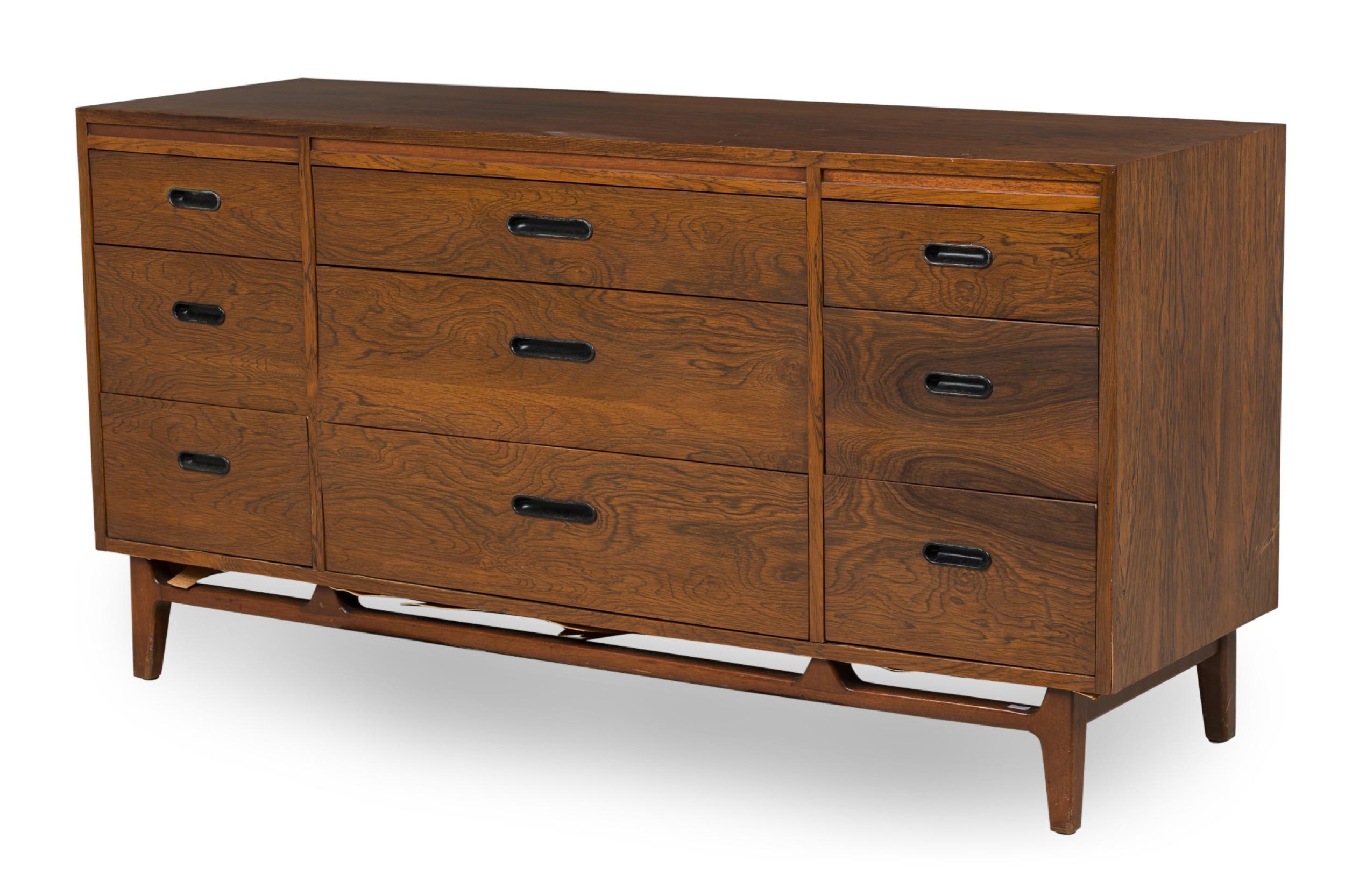Credenza / cassettiera in palissandro danese moderna della metà del secolo con tre cassetti centrali affiancati su entrambi i lati da tre cassetti più stretti, tutti con tiretti ovali stretti foderati di metallo, appoggiati su una base a traliccio