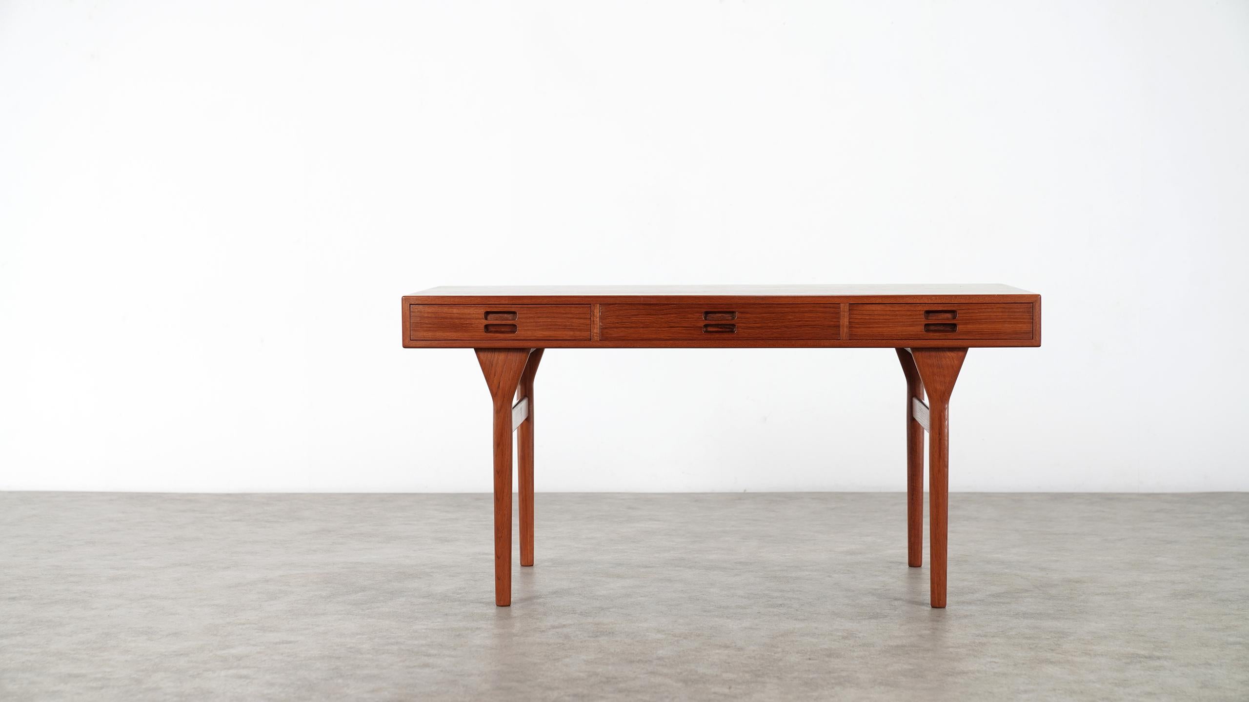 This elegant design by Nanna & Jørgen Ditzel serves as a desk, a writing table, library table, or even a console table in a large space. 

The spare, minimal form is delightful from every angle. 
Impeccably constructed by Søren Willadsen, the