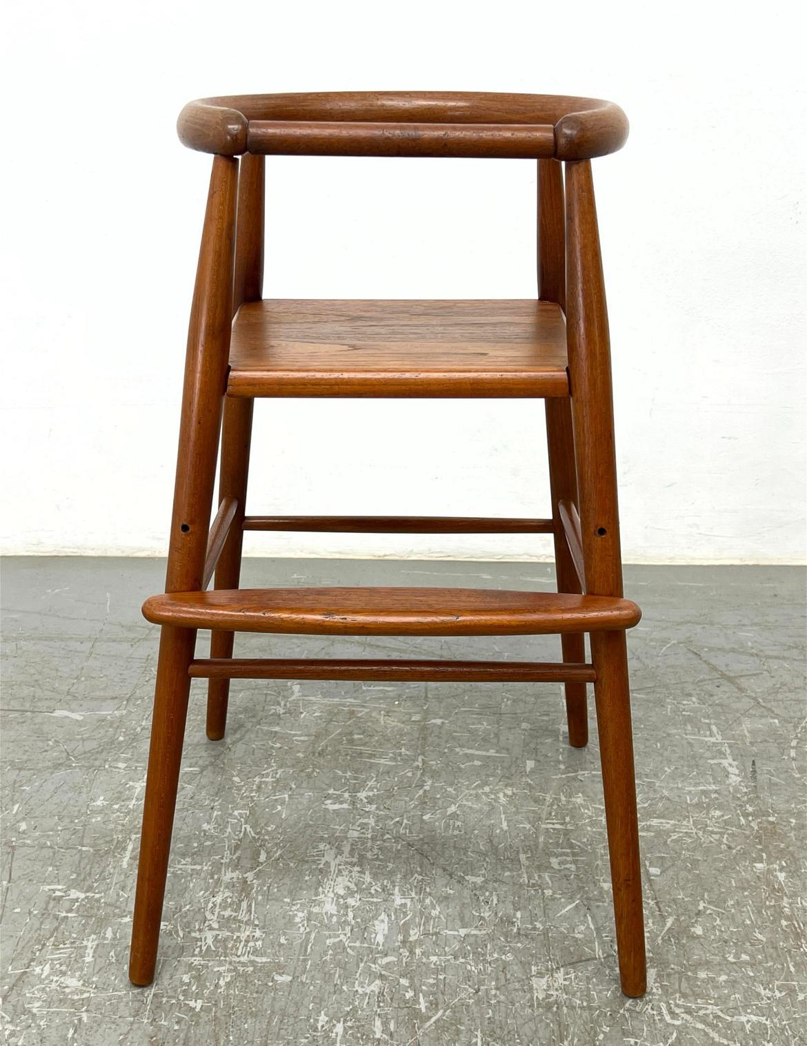 Nanna Ditzel teak Childs high chair stool Danish Mid-Century Modern. Solid teak wood. Has removable front teak bar. Made in Denmark. Beautiful design. Circa 1960 has original label - located in Brooklyn NYC.

Dimensions: H: 28 inches: W: 16 inches: