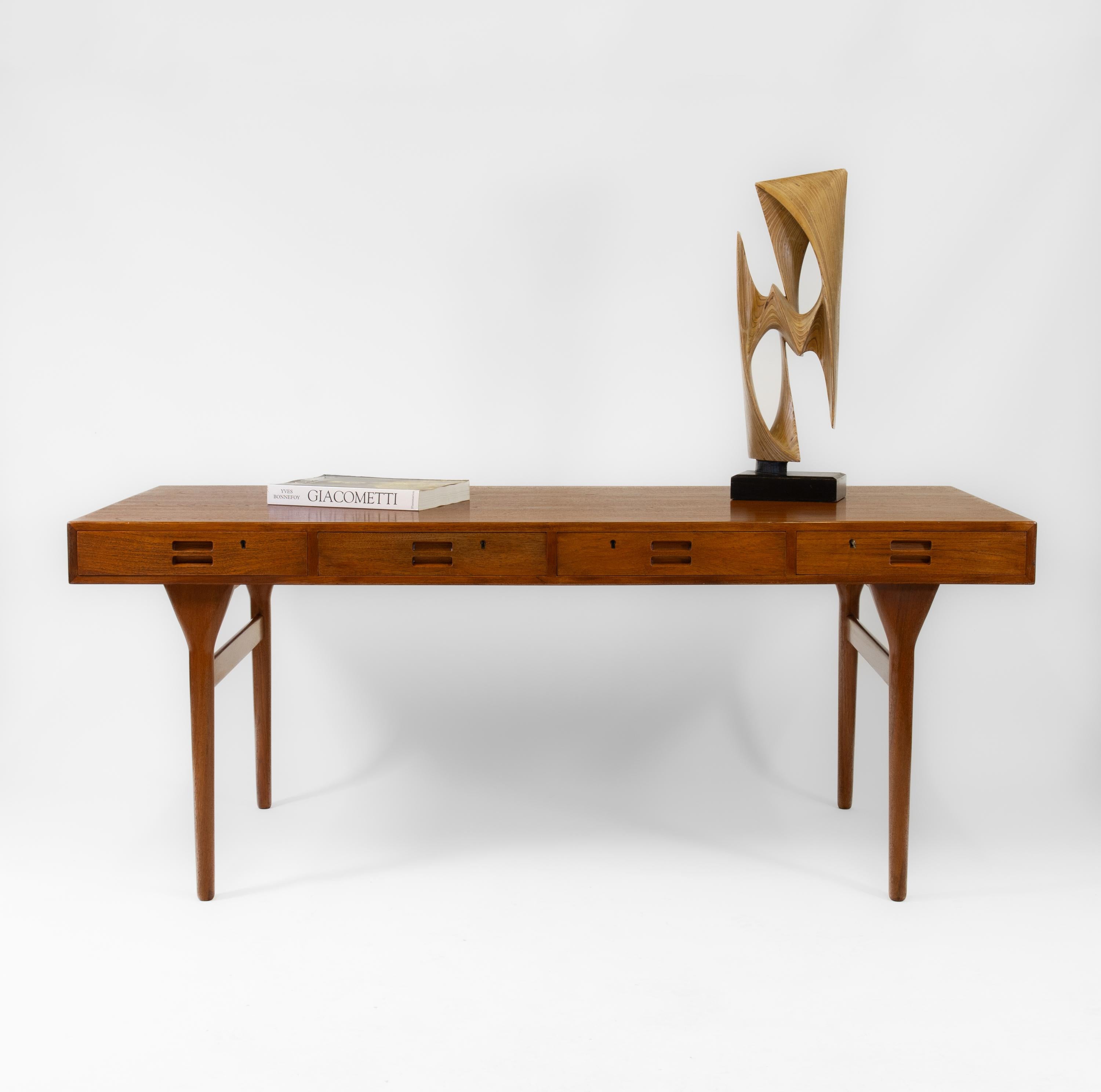 A super sleek iconic Danish mid century teak four drawer desk designed by Nanna Ditzel. Circa late 1950's.

Affectionately known later as the cassette-shape desk, it has been re-finished by hand, still retaining a few light authentic marks to
