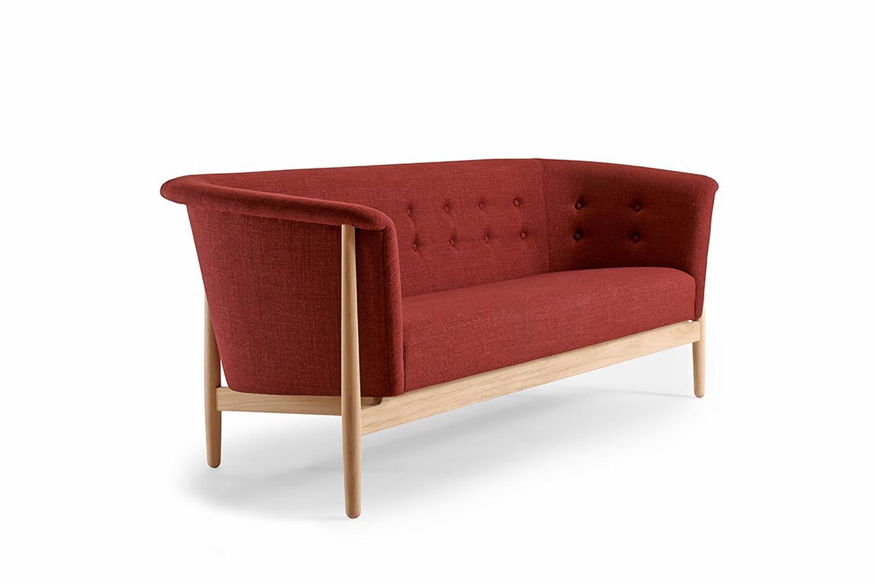 Designed by Nanna + Jørgen Ditzel in the 1950s, this stunning model is known as the Vita sofa. The silhouette pulls from traditional forms but is crafted in an open, organic design. Contrasting fabrics and button tufting adorn the upholstery