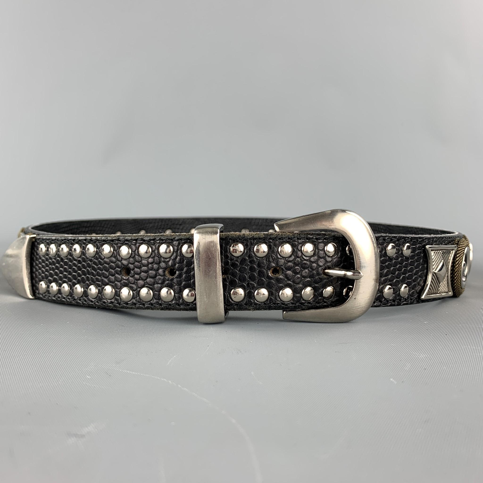 NANNI belt comes in a black & silver leather featuring silver tone metal designs throughout featuring studded details and a buckle closure. Made in Italy.

Very Good Pre-Owned Condition.
Marked: 90/36

Length: 41 in. 
Width: 1.25 in. 
Fits: 33 in. -