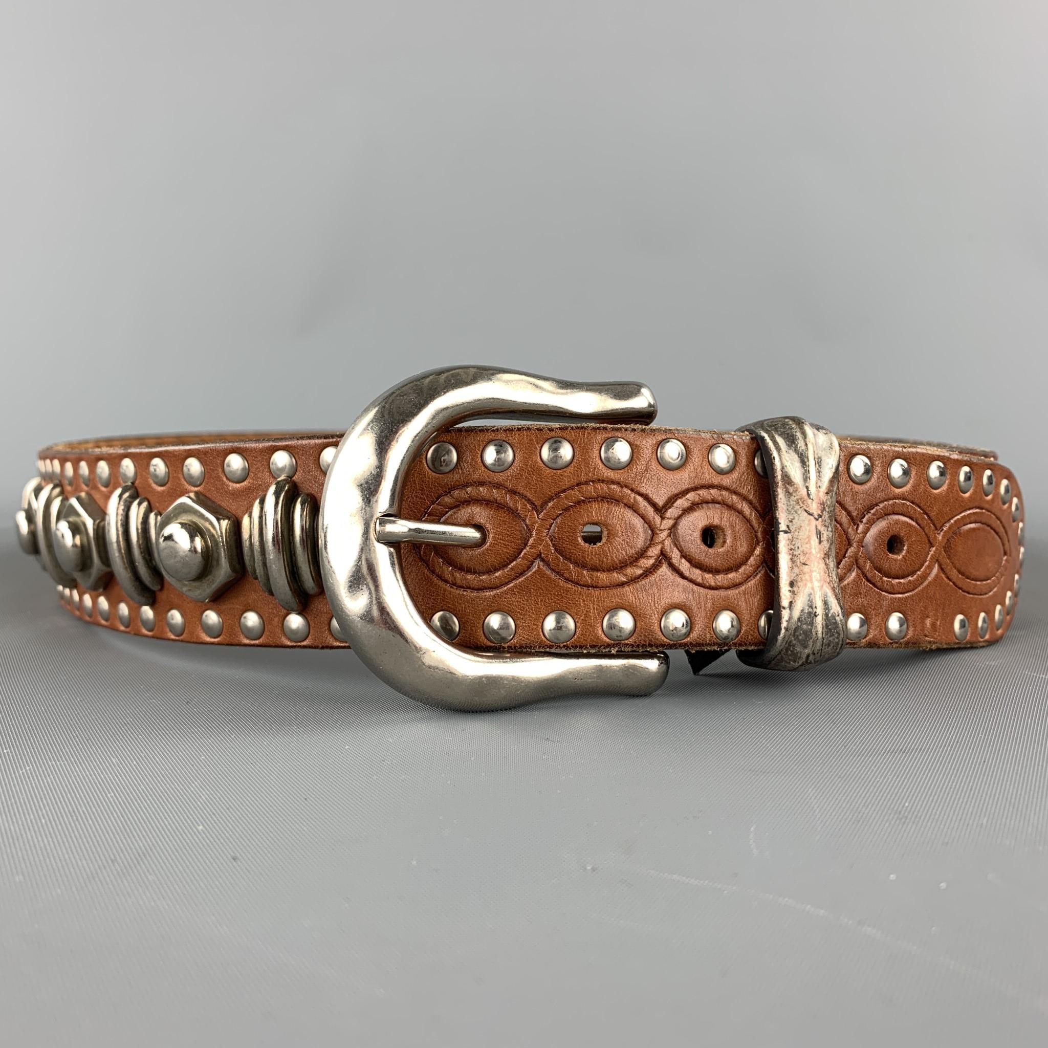NANNI belt comes in  tan leather with silver tone metal designs throughout featuring studded details and a buckle closure. Made in Italy.

Ver Good Pre-Owned Condition.
Marked: 90/36

Length:40.5 in. 
Width: 1.5 in.
Fits: 33 in. - 36 in. 
Buckle: 2