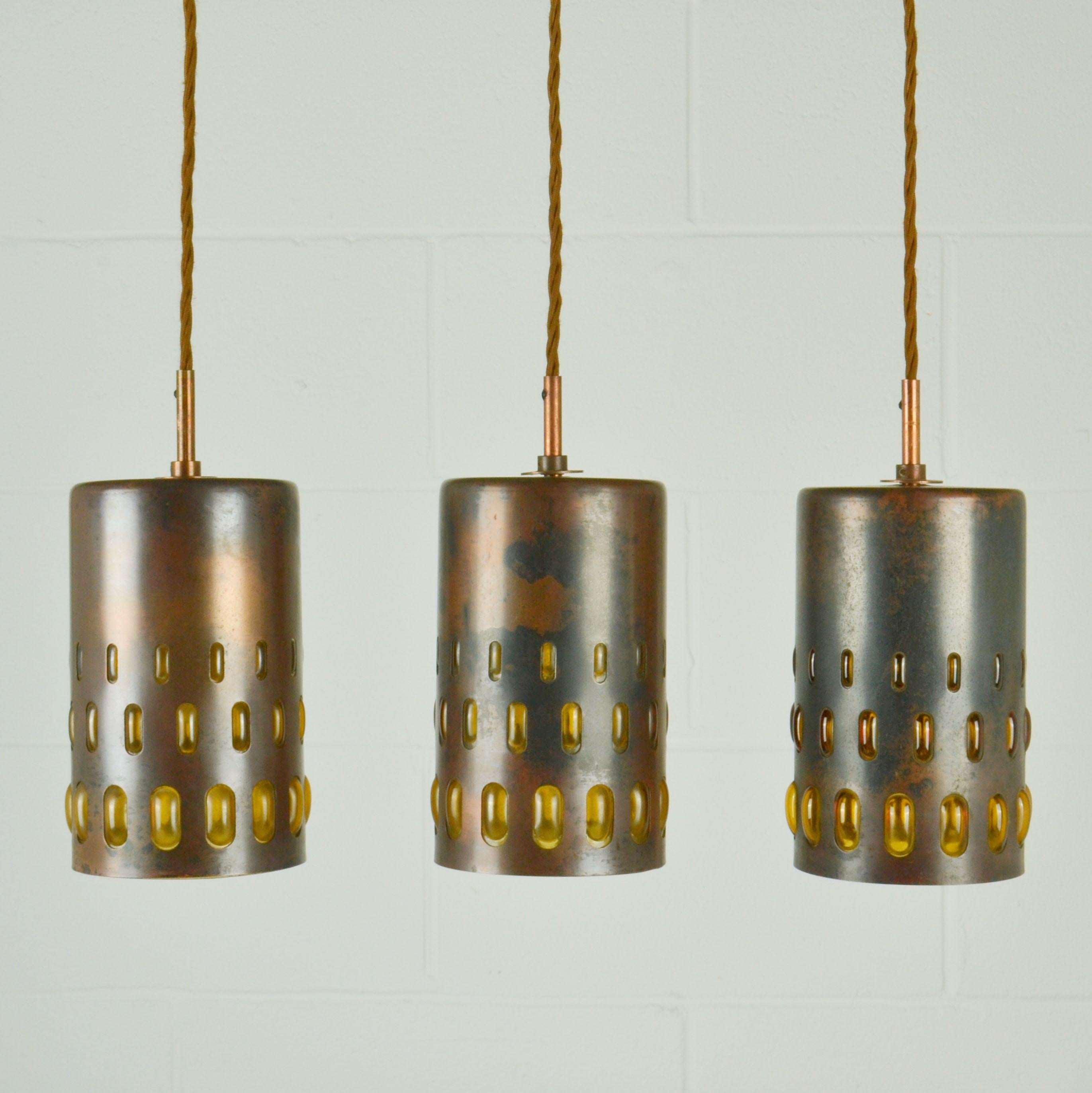 Ensemble de cinq lampes suspendues en verre ambré de forme conique, fabriquées à partir de verre soufflé et de cuivre oxydé. Ils sont tous uniques dans leur exécution. Le verre expansé d'un ambre profond est soufflé avec régularité dans des cadres