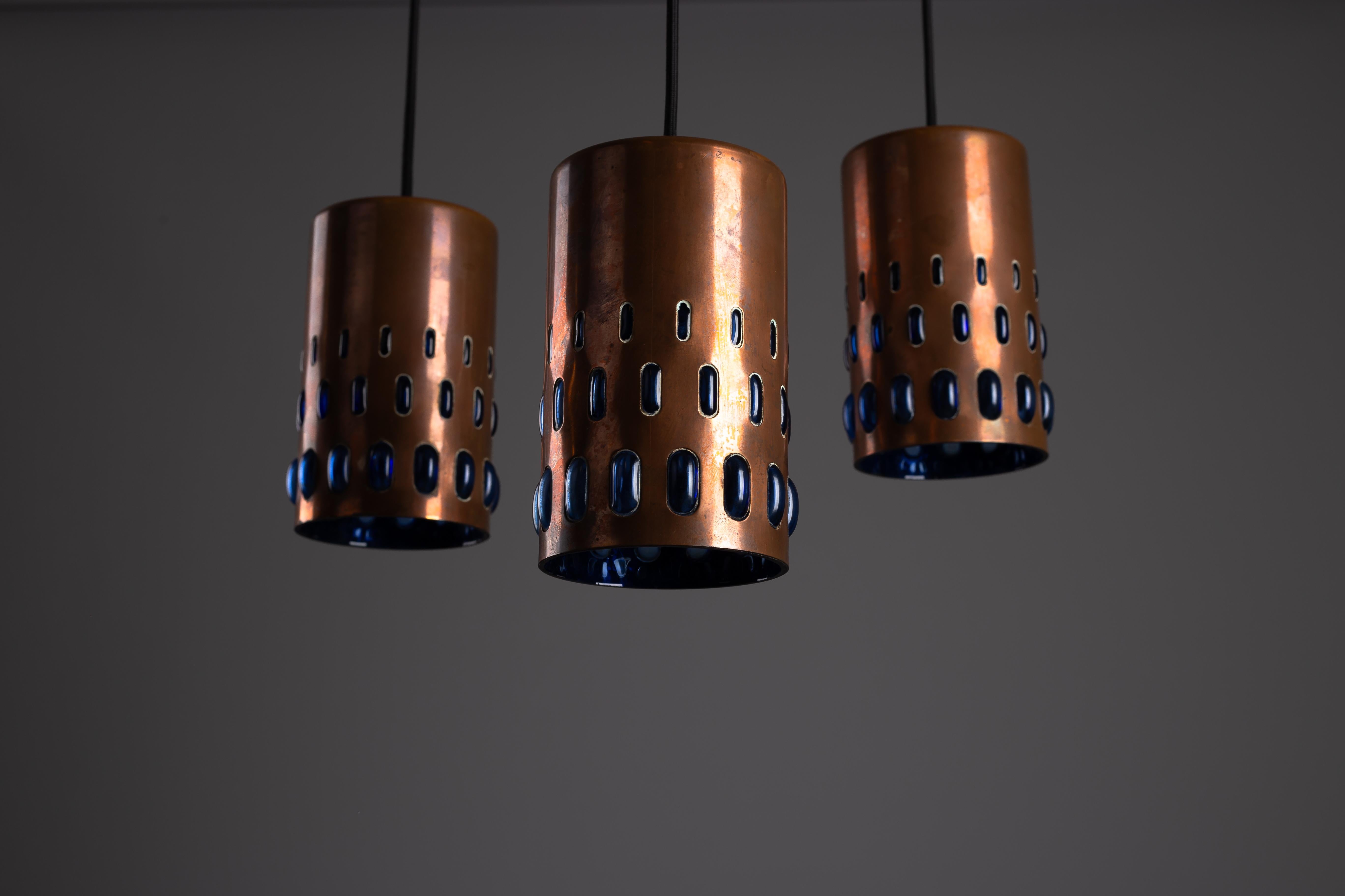 Ti presentiamo lo squisito set di 3 pendenti in rame degli anni '60 di Nanny Still per RAAK Amsterdam. Questi sorprendenti pendenti fondono perfettamente lo stile brutalista con l'eleganza del rame e del vetro soffiato, rendendoli un'aggiunta senza