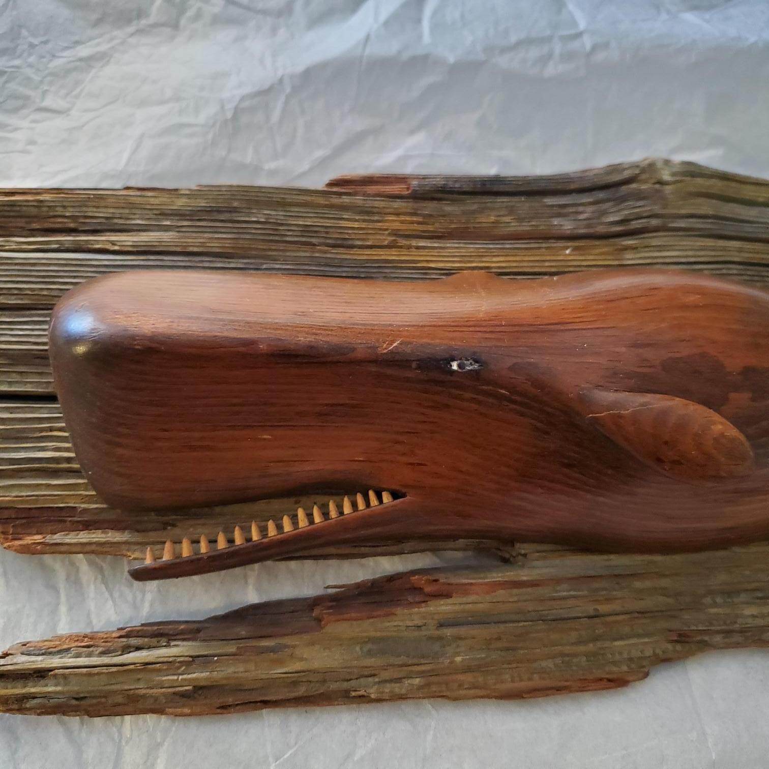 Vintage hand carved sperm whale by Nantucket artist William J. Dickson, 1967, a smoothly carved pine sperm whale with upraised flukes and open mouth exposing teeth, mounted on weathered barn board plank, signed and dated W.J. Dickson, 1967 on the