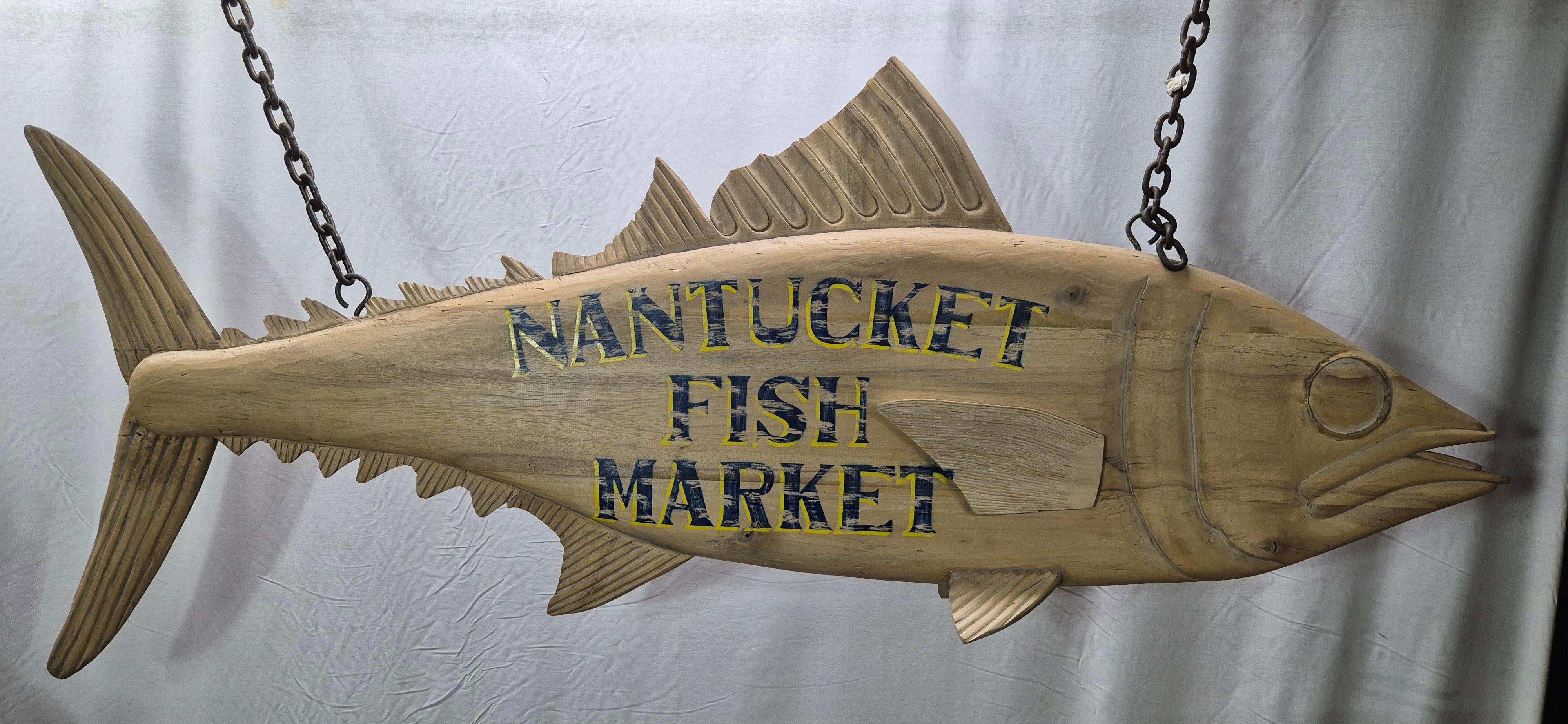 Six foot Atlantic tuna with 'Nantucket Fish Market' painted decoration in blue letters. Distressed finish. Carved details include fins, gills, eyes, snout, etc. Fitted with iron hanging chains.

Weight:    33 lbs.
Overall Dimensions:    24