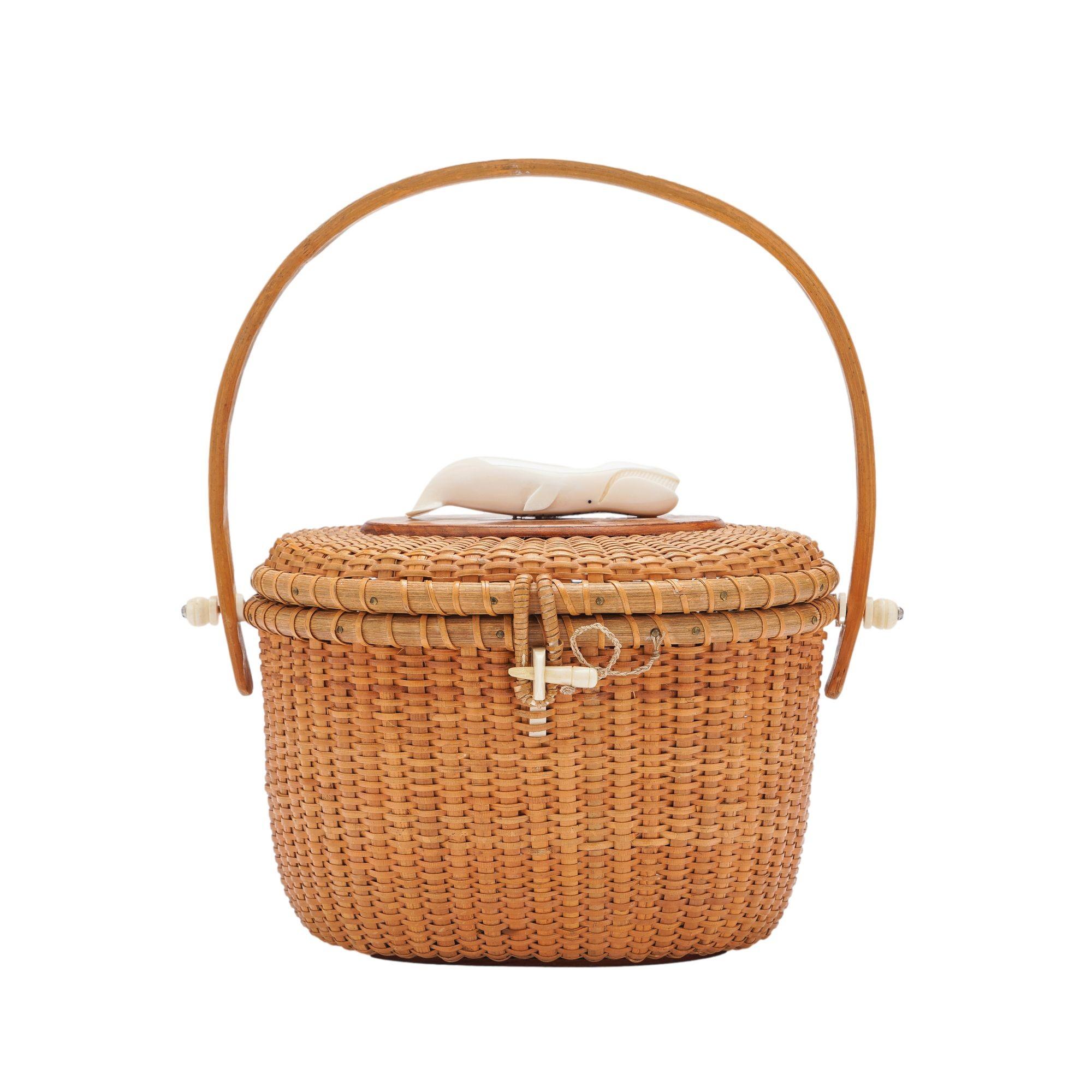 Nantucket lightship handbag in woven split bamboo with a distinctive carved whale mounted on top of the basket to the burl walnut lid plate. The basket is fitted with bone hinge pins and clasp, and rests on an oval walnut footing.

Nantucket, Rhode