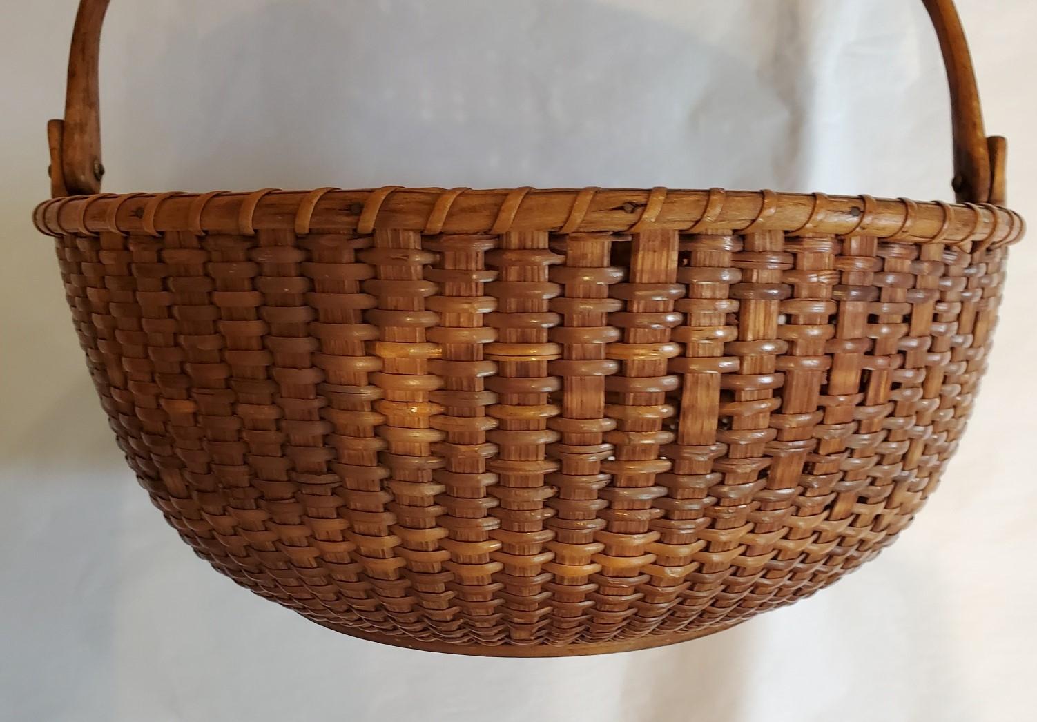 Antique Nantucket Lightship Basket from the South Shoals Lightship, attributed to Captain Thomas James (Nantucket: 1811 - 1885), circa 1870s, an early round, open Nantucket basket with wooden splint staves, cane weave, carved swing handle attached