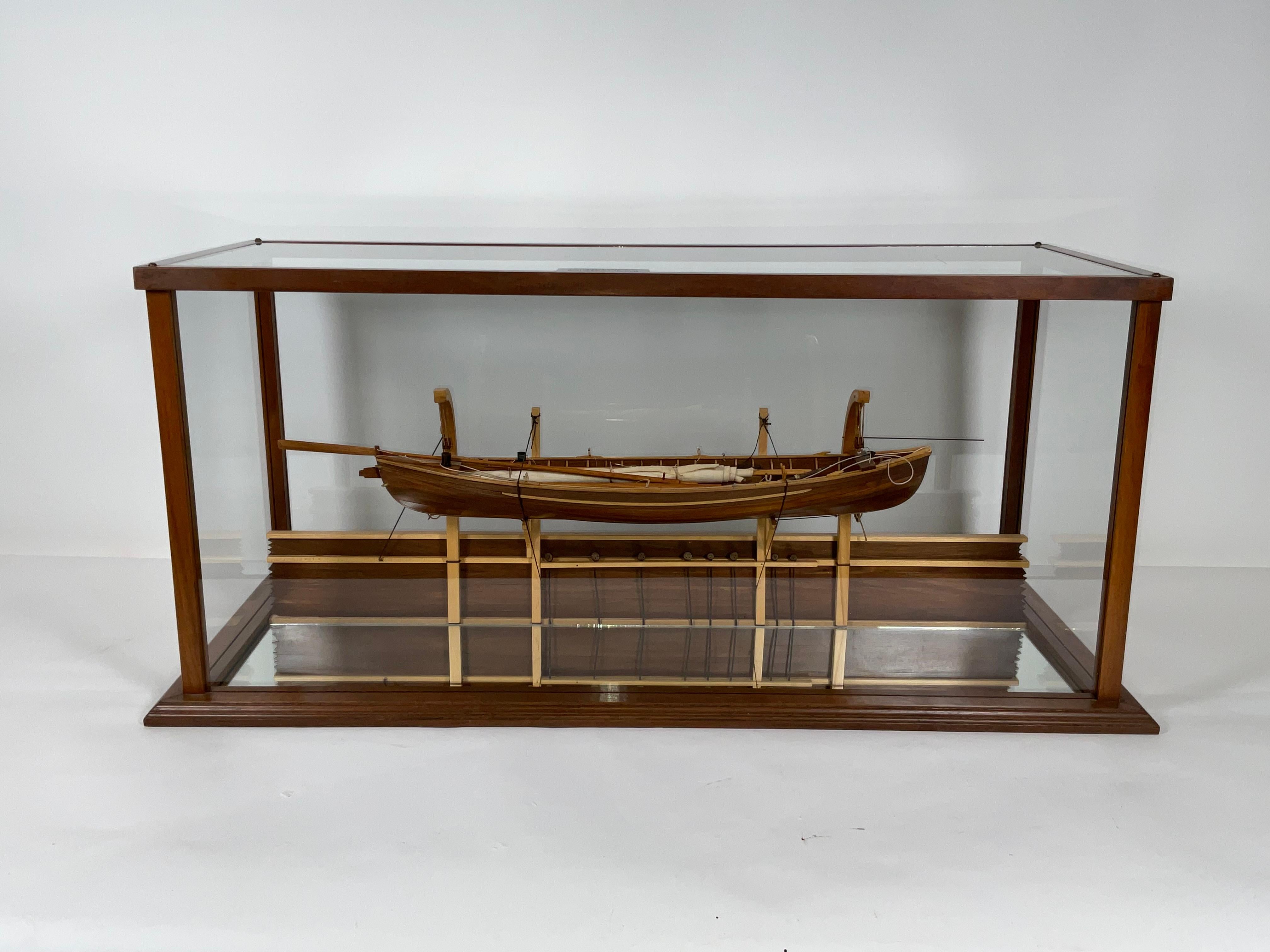 Modèle de baleinière nantucket monté sur une section du pavois d'un navire baleinier. Les détails comprennent les avirons, le mât, la voile, les harpons, les lances, les baquets de ligne, etc.etc. Monté dans une vitrine en verre personnalisée avec