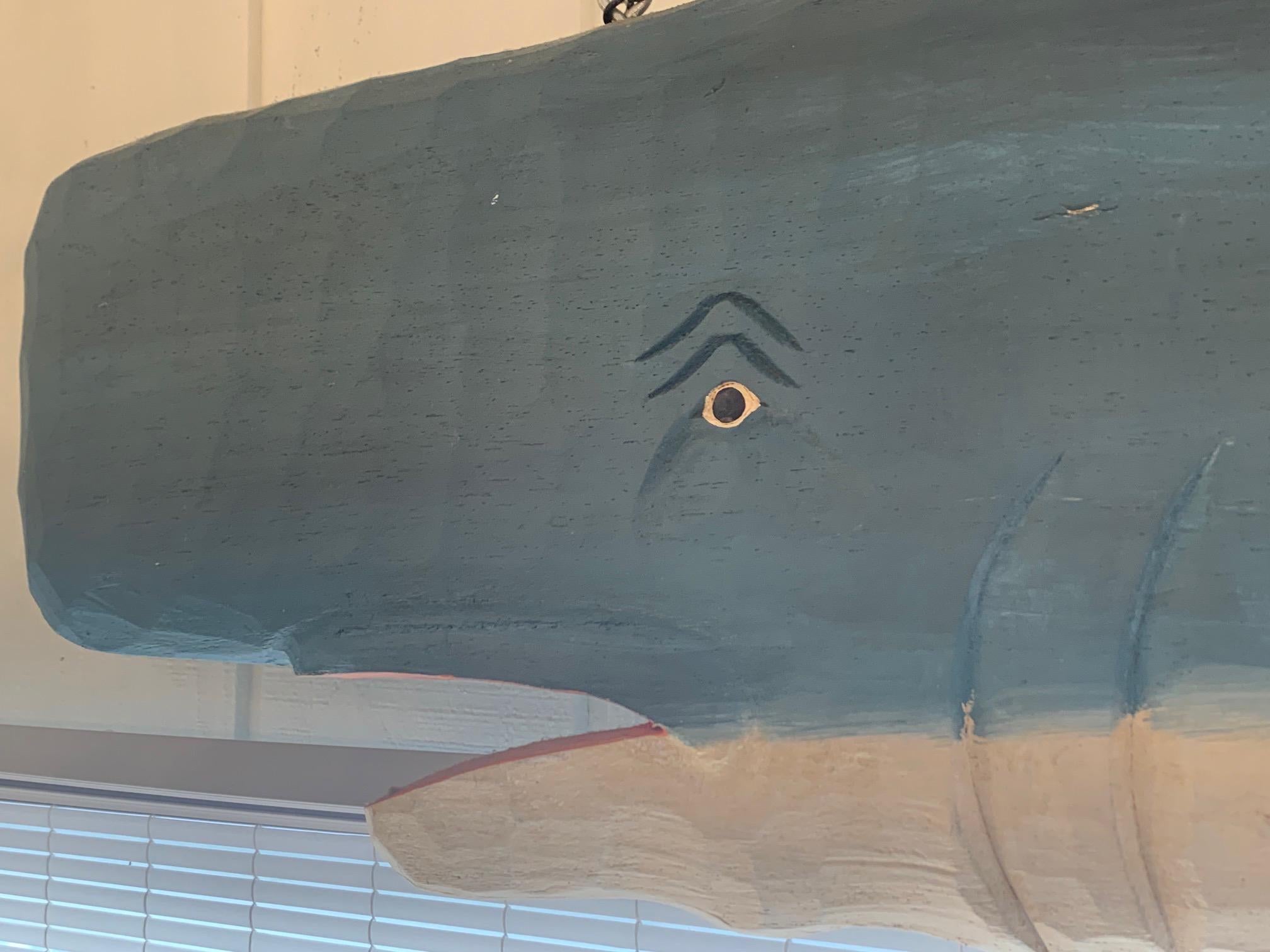 An eye catching Nantucket large painted and carved wood hanging whale sculpture for the wall in grey blue and white.