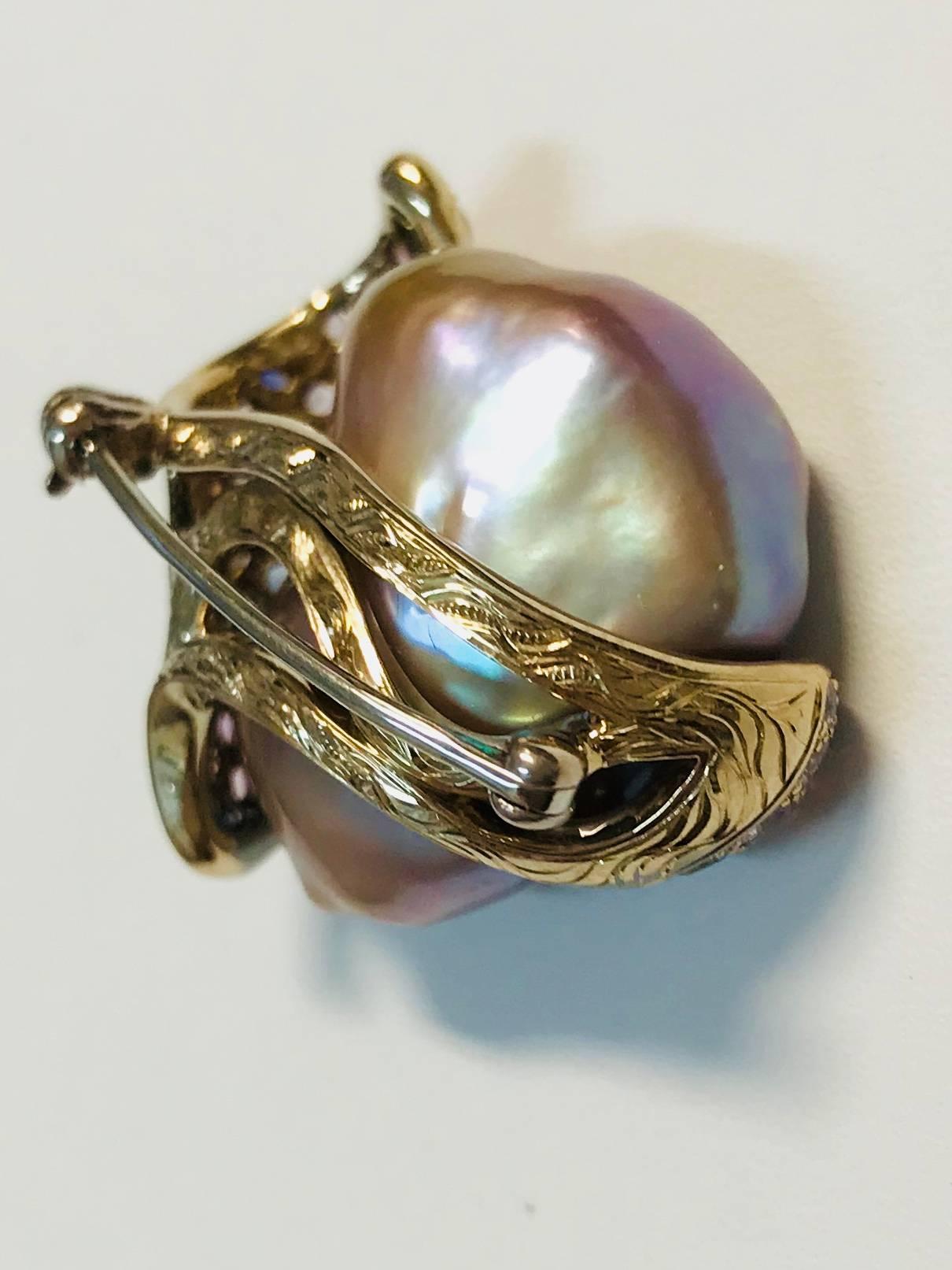 Beautiful Chinese freshwater gray pearl encased in a waved of 18K yellow gold set with approximately 74 multicolored sapphires and diamonds. 

Internationally award winning designer Naomi Sarna creates gem carvings and jewels of unusual beauty. She
