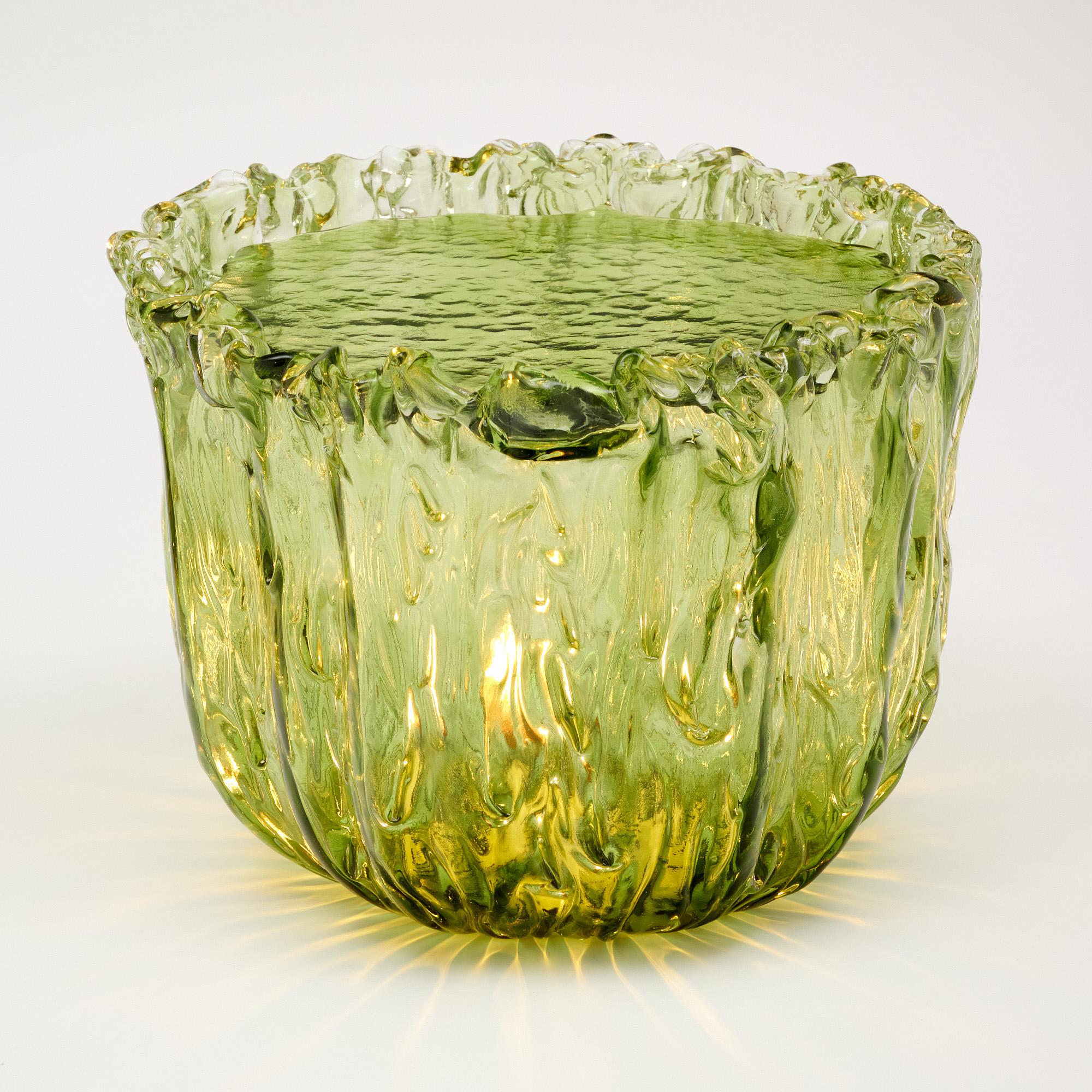 Mesa auxiliar de cristal de Naoto Fukasawa creada en Murano, Italia. La mesa es de cristal verde soplado a mano con una forma orgánica. Una tapa de cristal independiente encaja perfectamente en la parte superior. Está electrificada por dentro para
