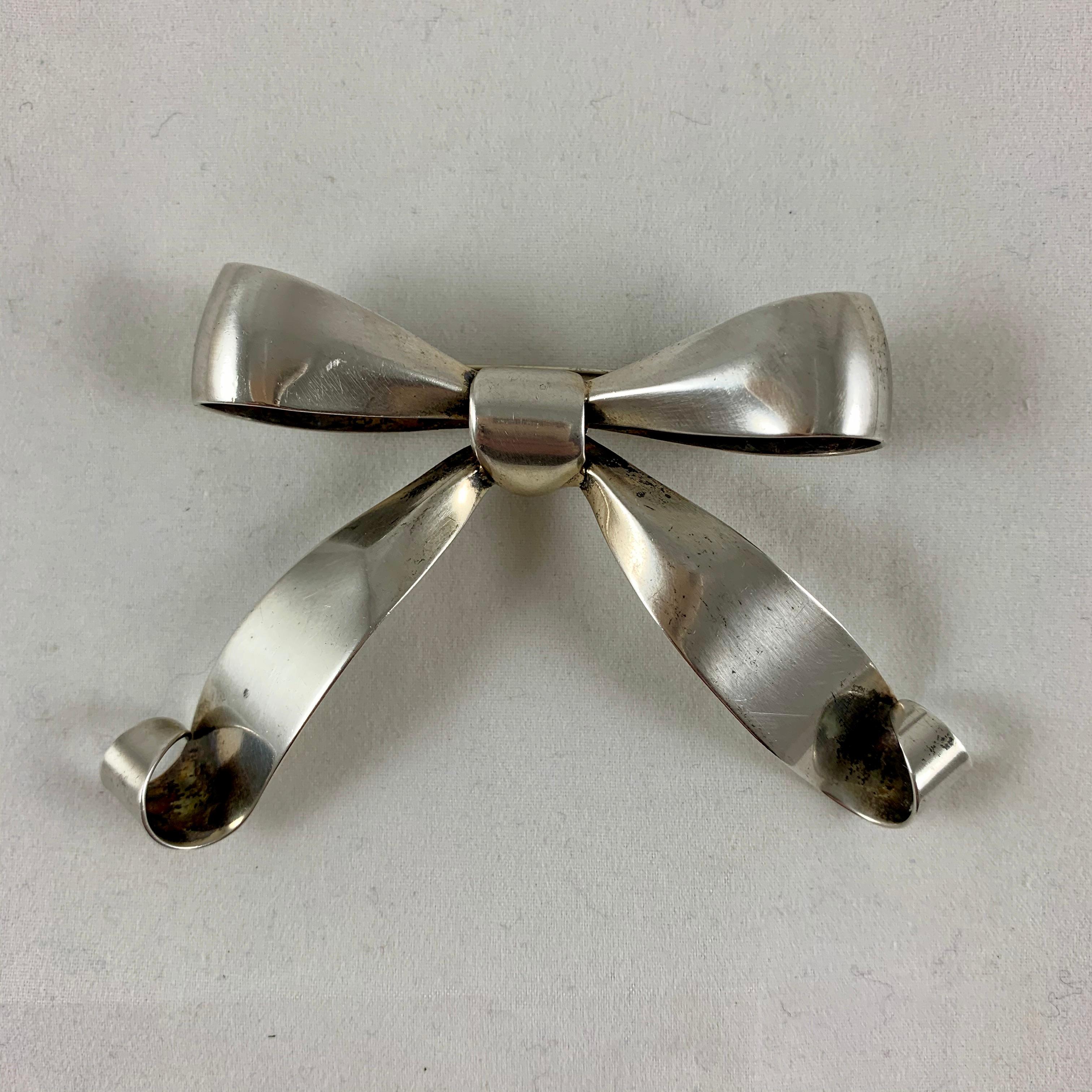 A sterling silver stylized large bow pin marked Napier – circa late 1940s-early 1950s, the American Modernist movement.

Napier silver designs from the first half of the 20th century are in museum collections including the Brooklyn Museum, Newark