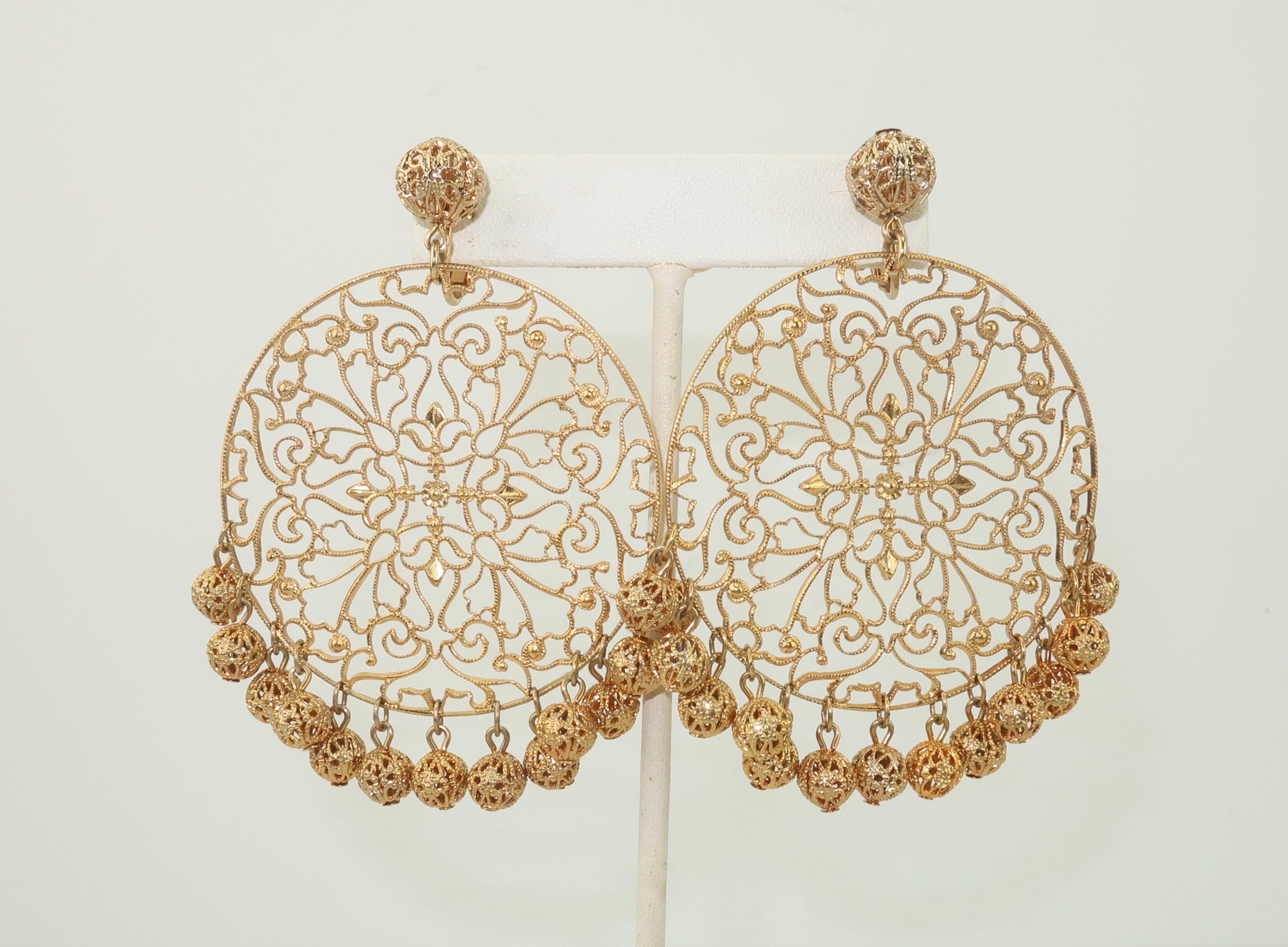 Get a little bohemian style with these gold tone filigree dangle earrings by the venerable American costume jewelry company, Napier.  An extra large filigree disk dangles from a ball base and is embellished with ball 'fringe' at the bottom.  They
