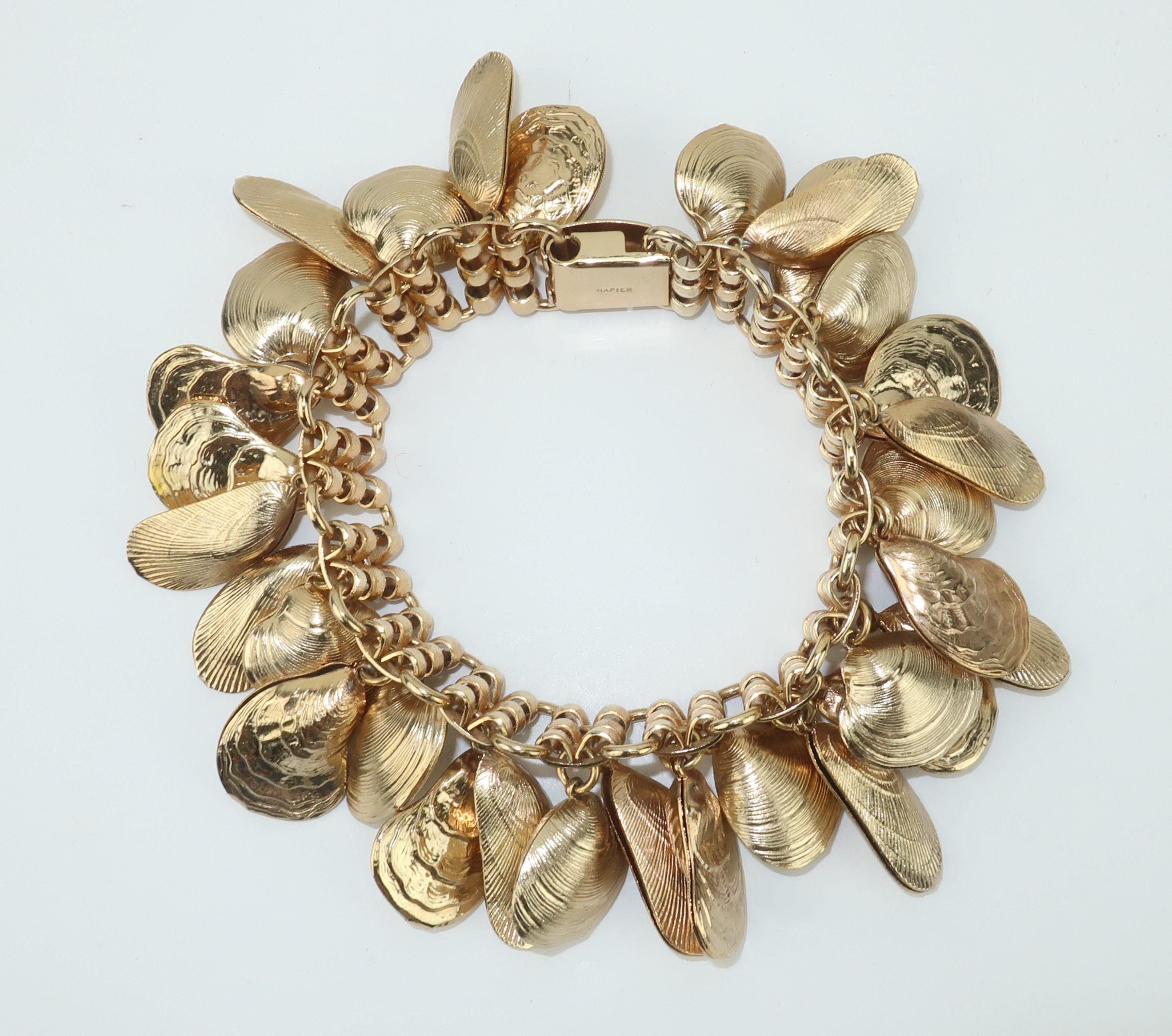 Let your 'charming' presence be known when wearing a 1960's Napier demi-parure of a charm bracelet and dangle earrings decorated with gold tone clam and oyster shells.  The bracelet has a box closure and the earrings sport clip on hardware.  All