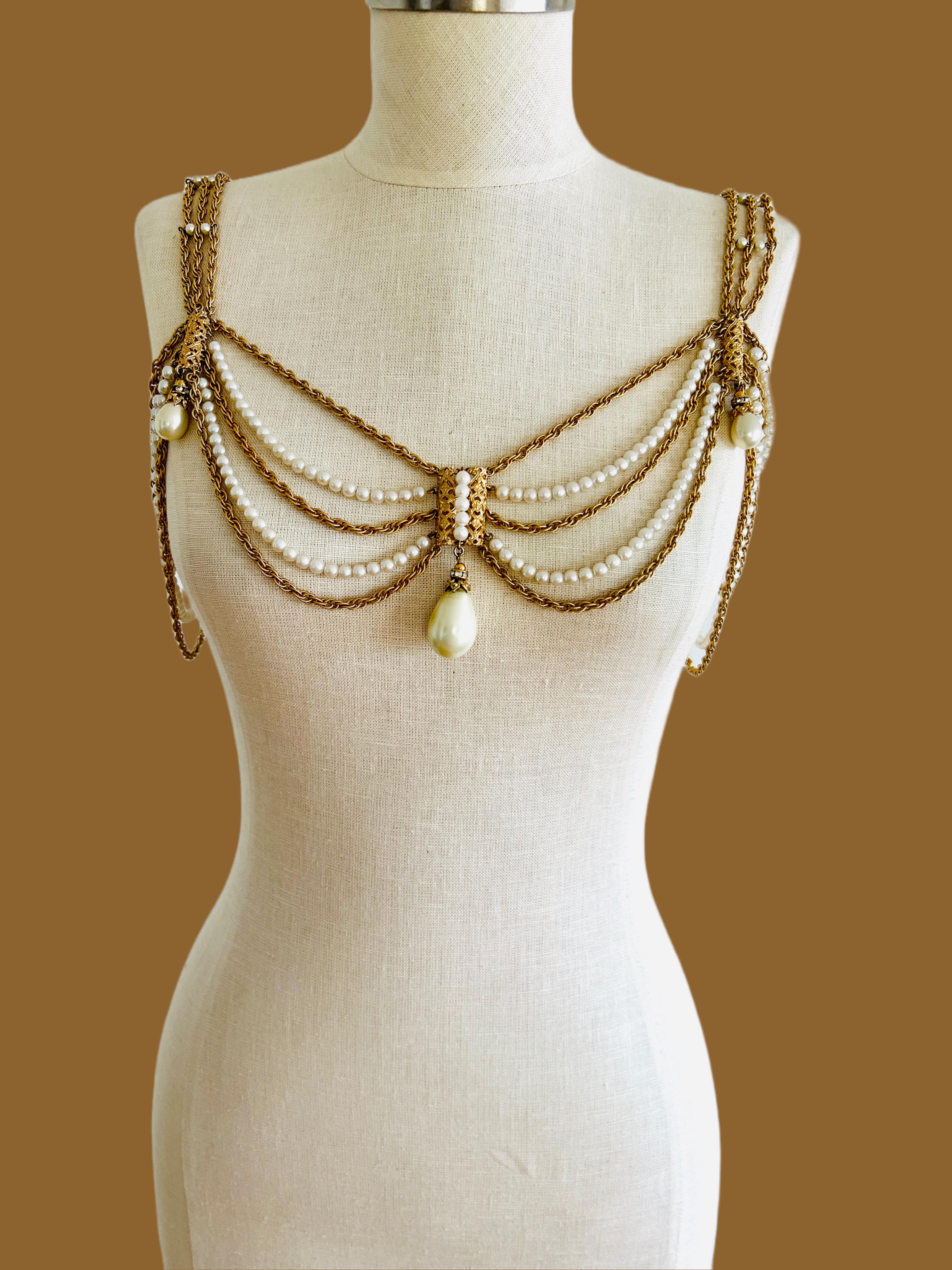 This Napier statement gold tone necklace, features several tiered chains and strands of imitation pearls. It is well-constructed with a hefty weight (306 grams). It can be worn in a variety of ways. It can be worn as a shoulder necklace, a bikini