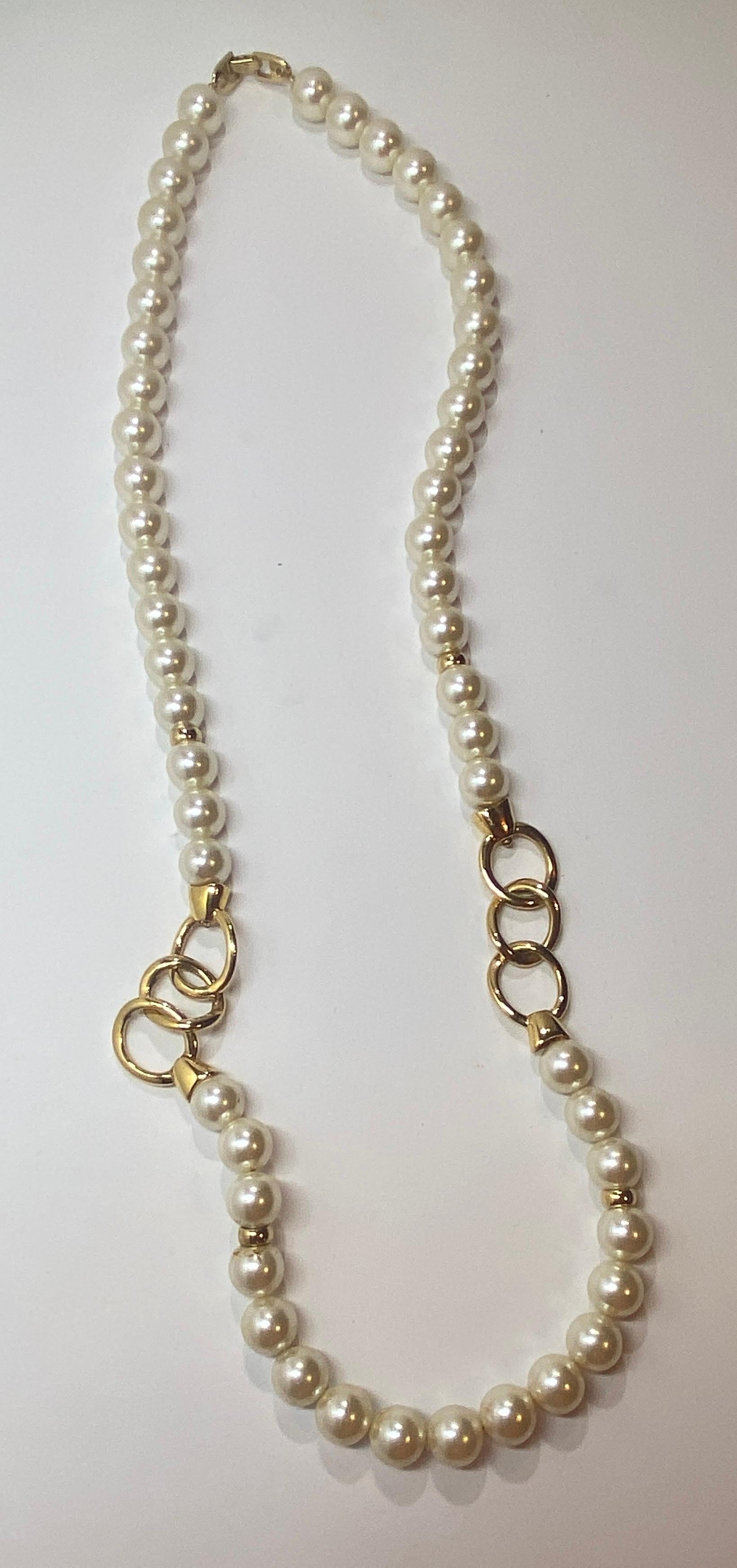 Napier's wonderfully elegant yet whimsical costume pearl, which measures 1/2 inch in circumference accented with polished gold hardware chain-link necklace, measures 30 inches in total length. The clasp is of polished gold hardware as well. Made in