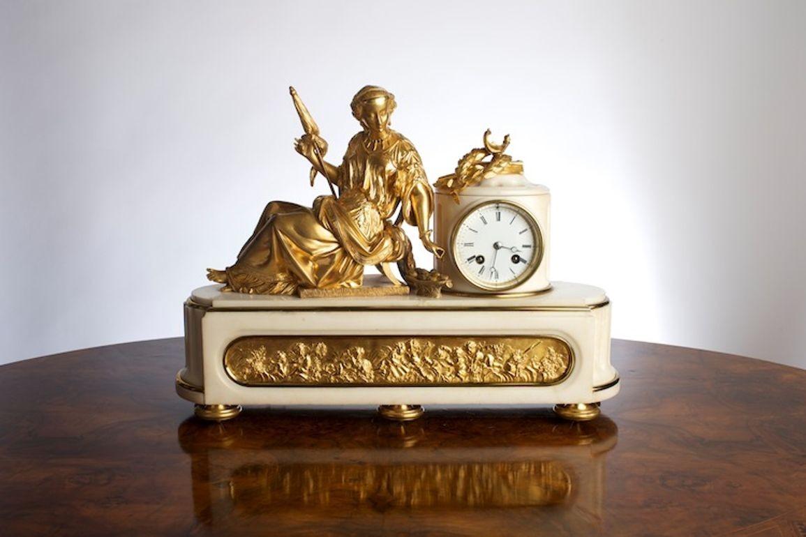 Magnifique pendule Napoléon III en bronze doré et marbre blanc. La base est ornée d'une frise baccanalienne dorée et une dame classique est assise sur six pieds en forme de boutons dorés.
Cadran émaillé avec chiffres romains, mouvement de huit jours