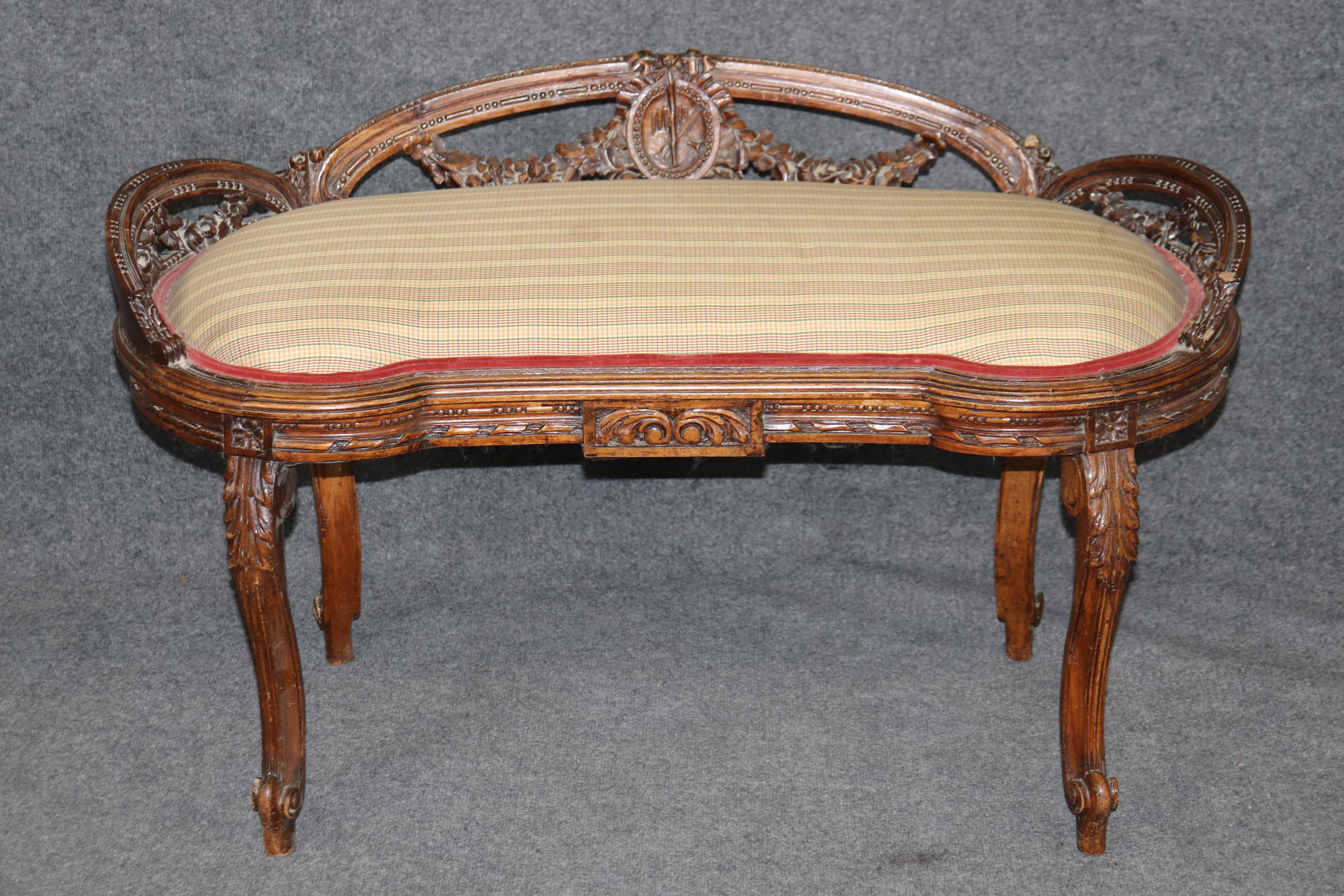 This is a gorgeous carved walnut window bench which could be considered Louis XV or Napoleonic in style. It is beautifully carved and the design is iconic. How often have you seen these in advertisements or magazines? This bench is in good condition