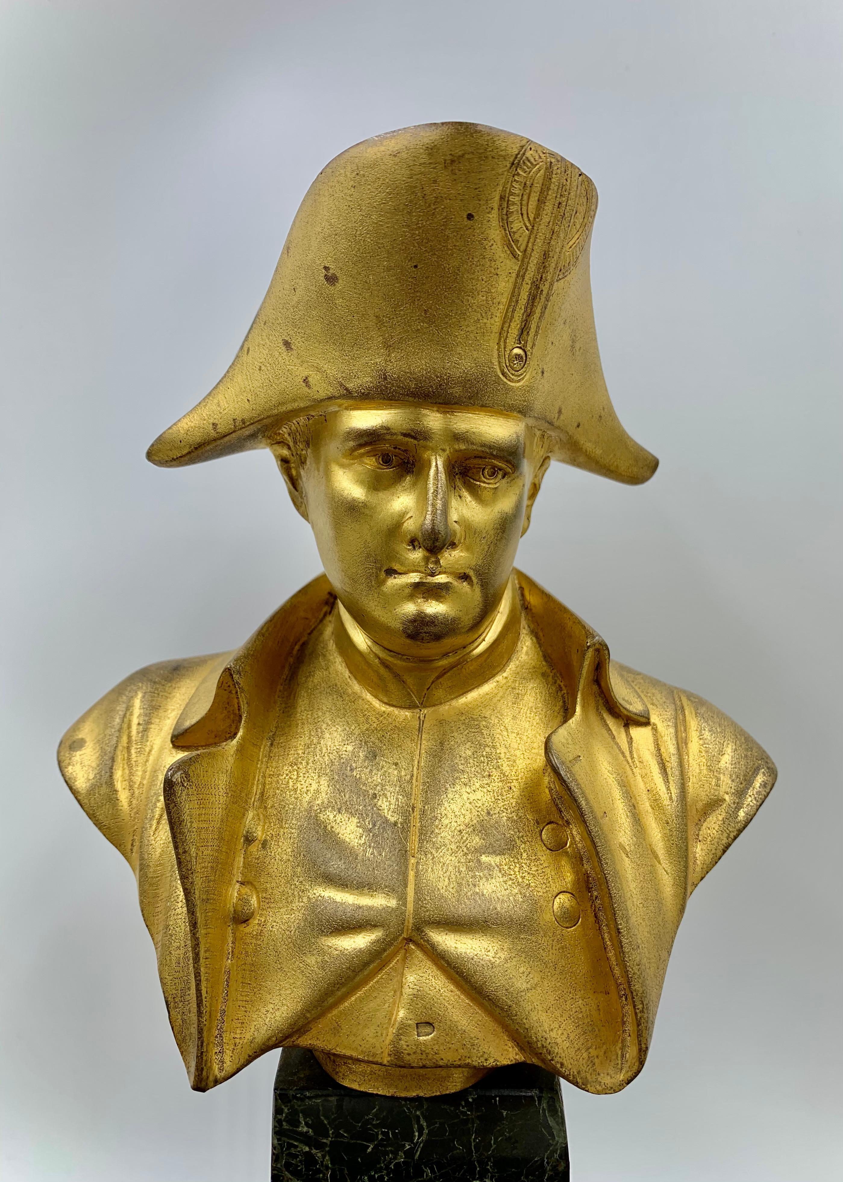 Beeindruckendes Tintenfass aus vergoldeter Bronze und Verde-Antico-Marmor mit einer Büste von Napoleon I. in der Mitte. Die Skulptur ist auf der Rückseite von Basil signiert und auf 1830 datiert, zwei Tintenfässer flankieren es. 
Ein wunderschönes