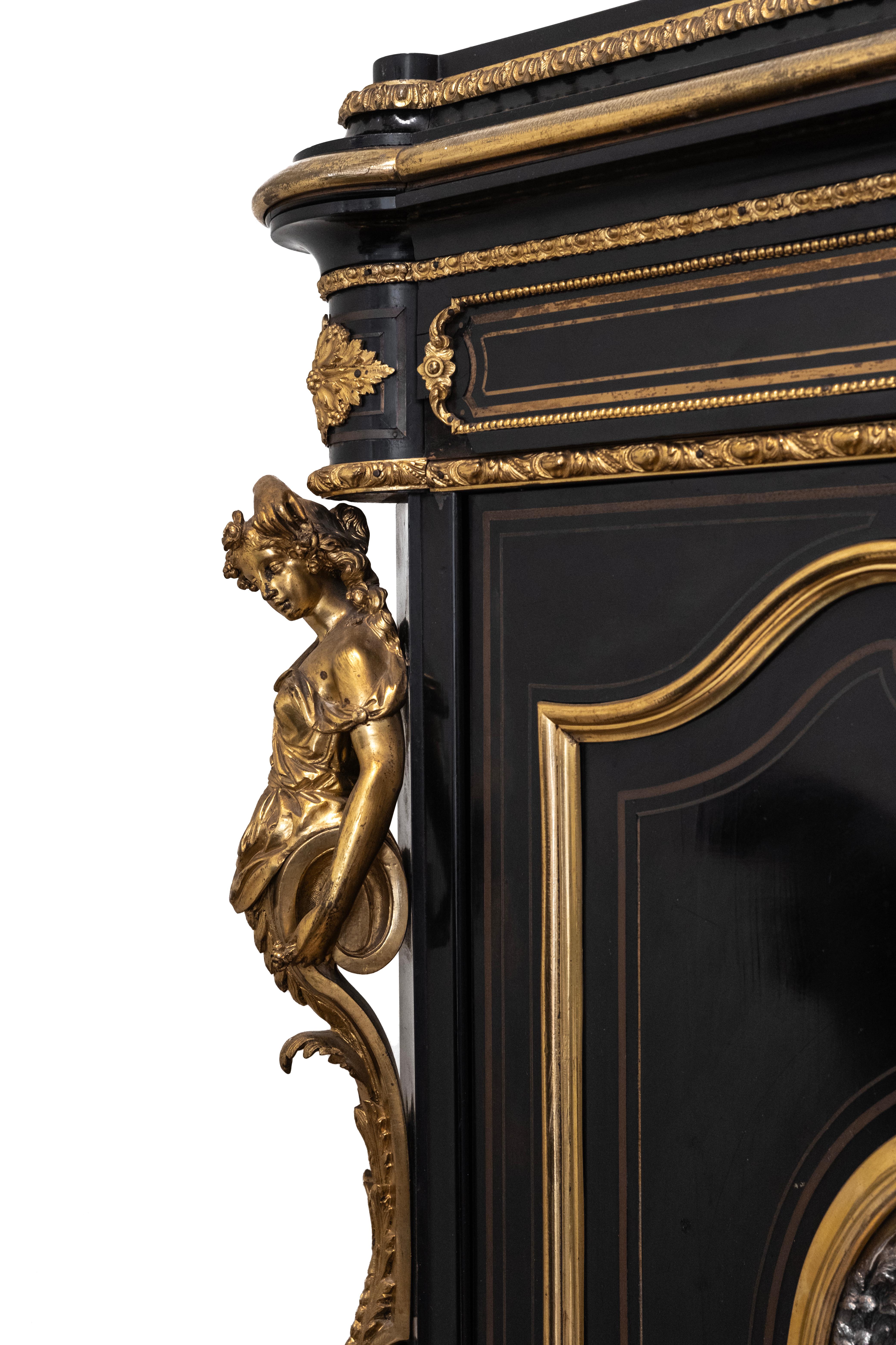 Napoleon III solid oak cabinet with ebony veneer and carved black marble top. The facade is framed with gilt bronze mounts of caryatids, and two doors are decorated with silver medallions, that depict cherubs playing in the garden. The interior is